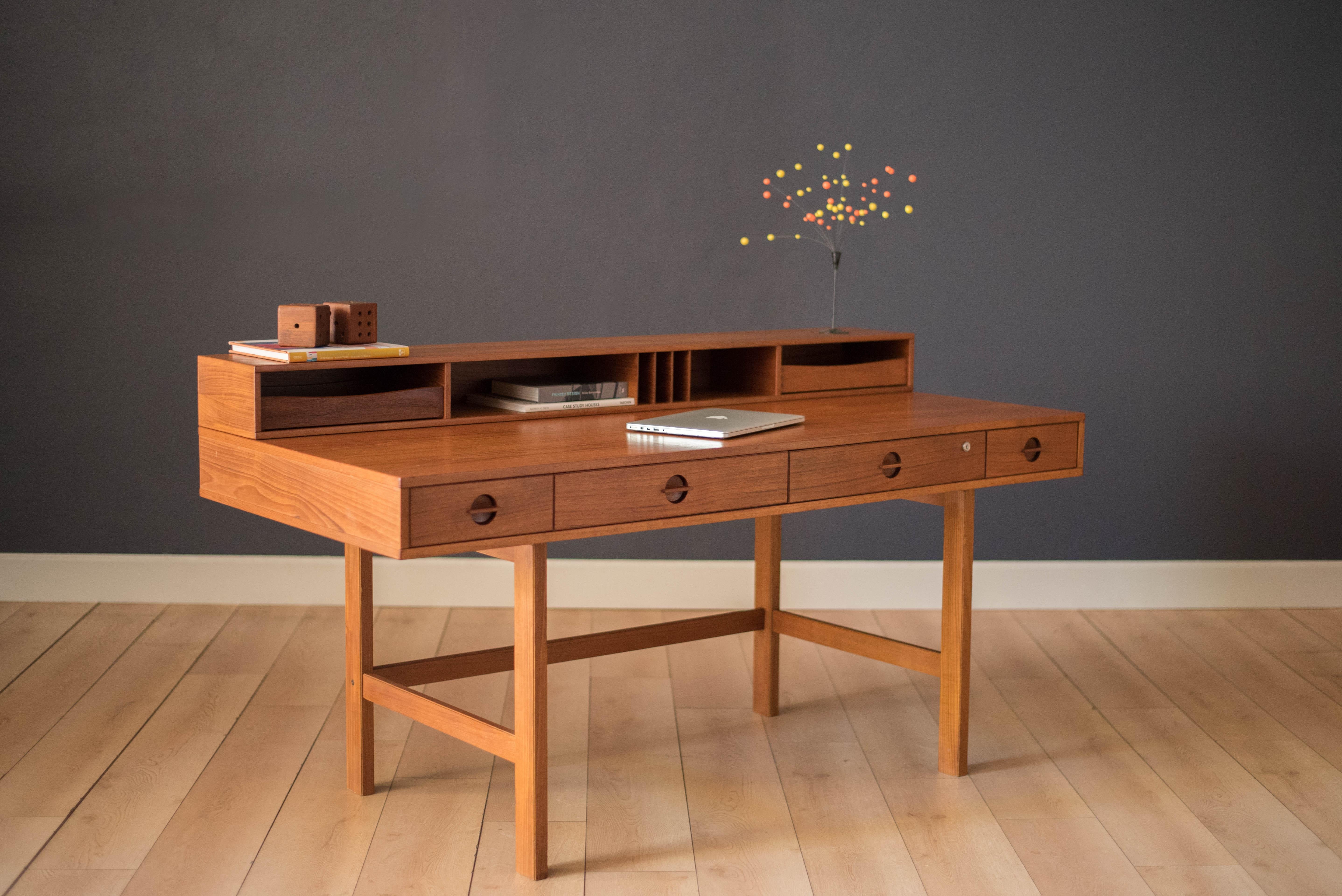 Vintage flip top writing partners desk designed by Peter Lovig Nielsen for Dansk, circa 1970s. This versatile piece offers plenty of storage featuring four drawers and an organized top shelf display. The backside is finished and can be showcased in