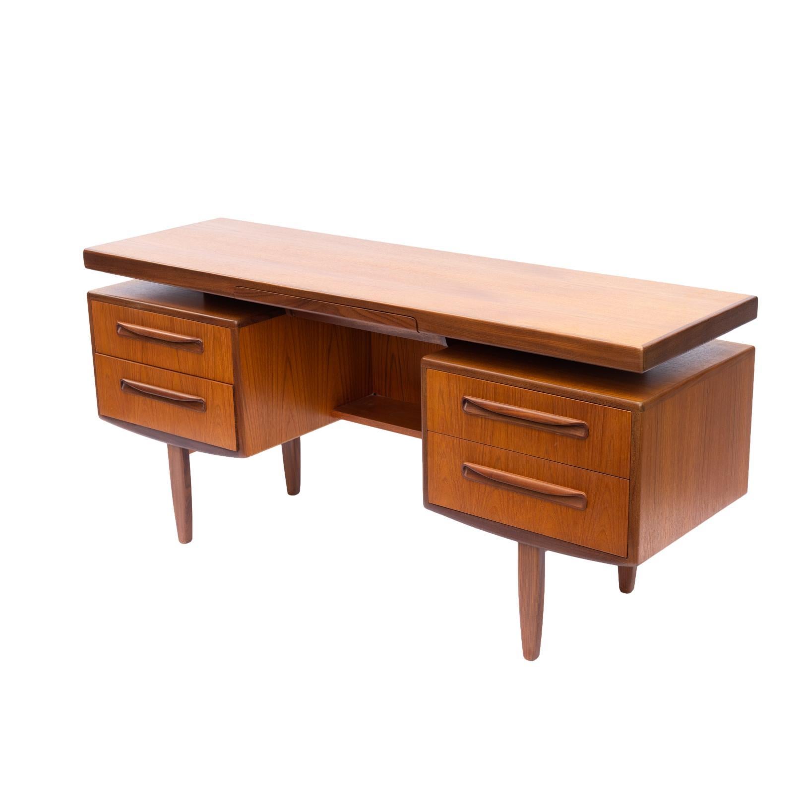 Mid-Century Modern G-Plan 'Fresco' desk/dressing table, English, ca. 1960. 
Featuring a floating top, contrasting afrormosia wood detailing, two drawers to each side, on solid teak legs.
British furniture designer Victor Bramwell (V.B.) Wilkins is