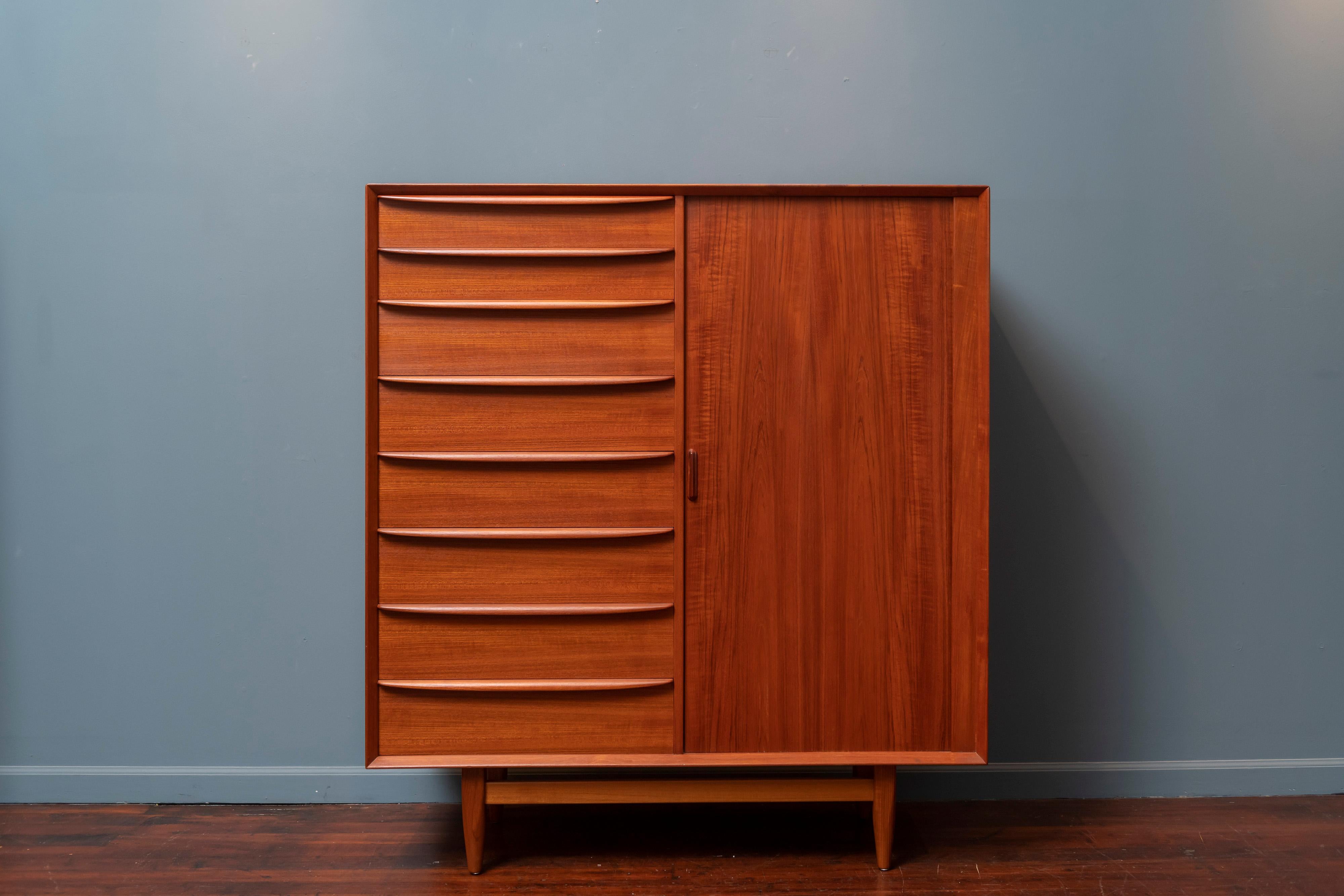 Mid-Century Modern teak gentleman's chest or tall dresser for Falster, Mobelfabrik Denmark. 
Featuring 17 drawers with 8 on the left and another 9 hidden behind a tambour door. Newly refinished and ready to enjoy.