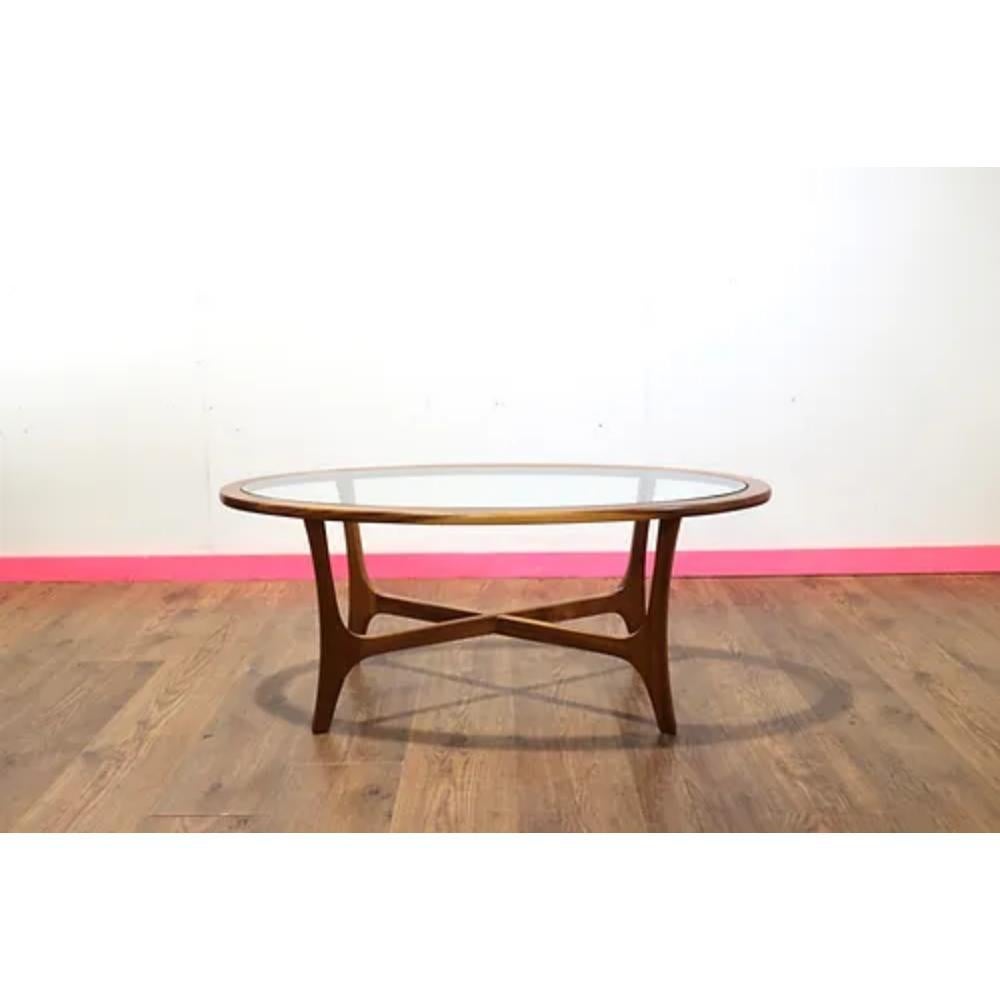 Introducing the Mid Century Modern Teak Glass Coffee Table by Stonehill, a stunning addition to any home. Crafted with elegant teak wood, this coffee table exudes mid-century style and sophistication. The fabulous sculpted legs make this piece a