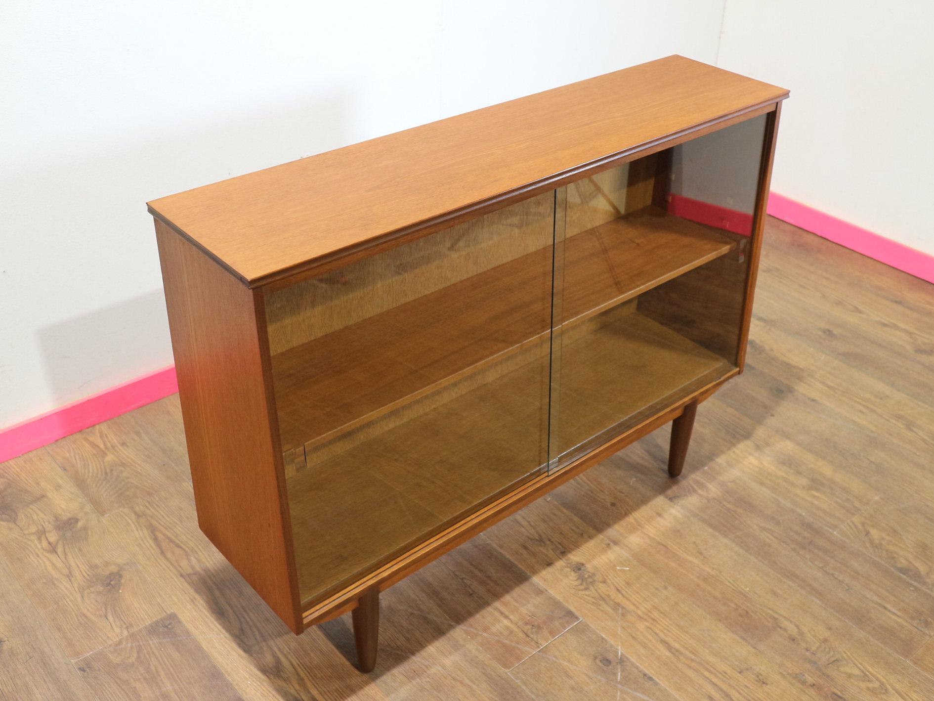 At Mid Century Traders, discover an elegant and stylish display cabinet with sliding glass doors that perfectly embodies the timeless charm of mid-century modern design. Crafted from luxurious teak wood, this china cabinet is not just a storage