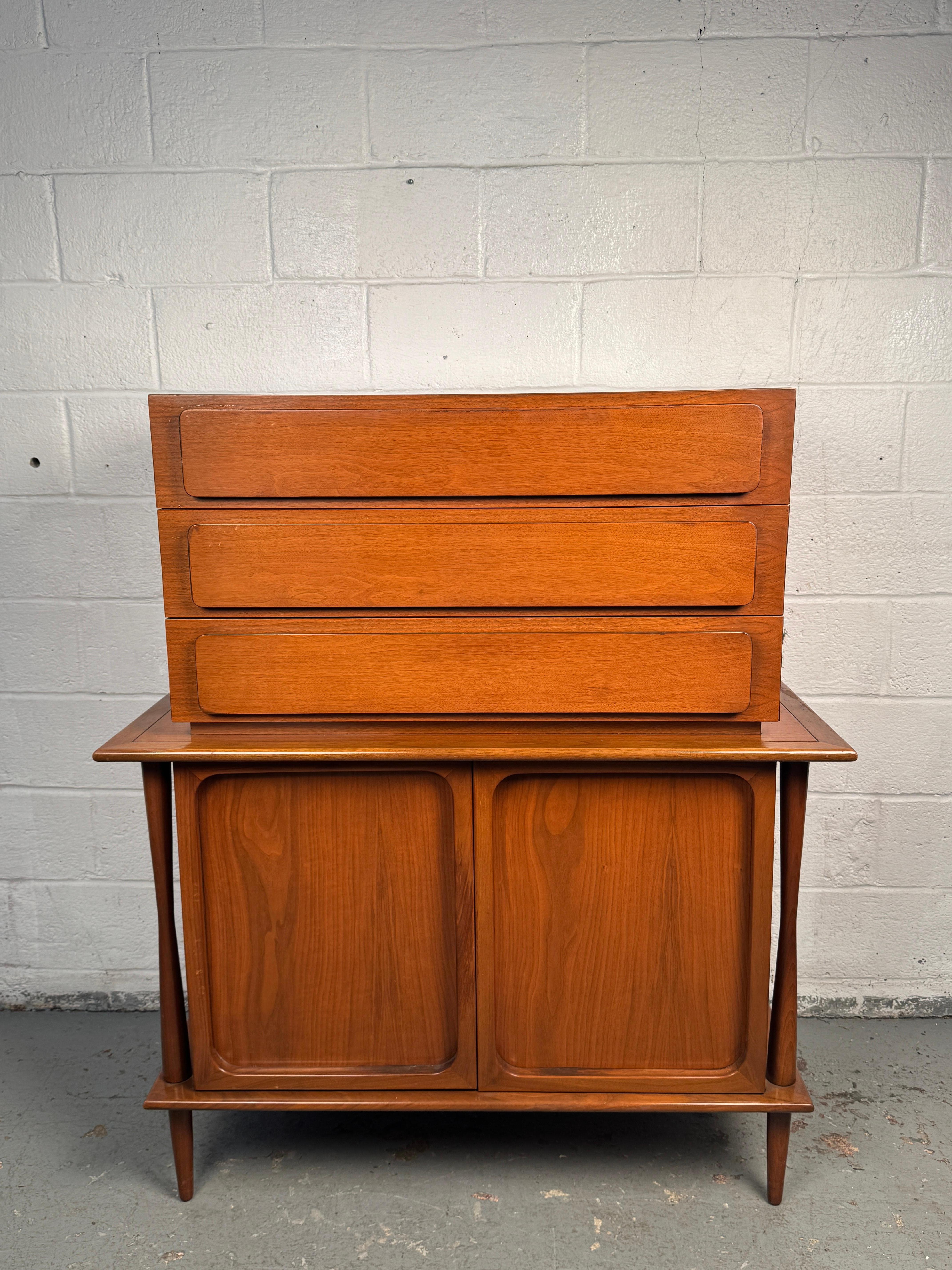 Elegant mid-century modern highboy crafted in warm teak, showcasing clean lines and rich grain. Designed with ample drawer storage and a sleek vertical profile, this piece embodies the simplicity and functionality of Scandinavian-inspired design. A