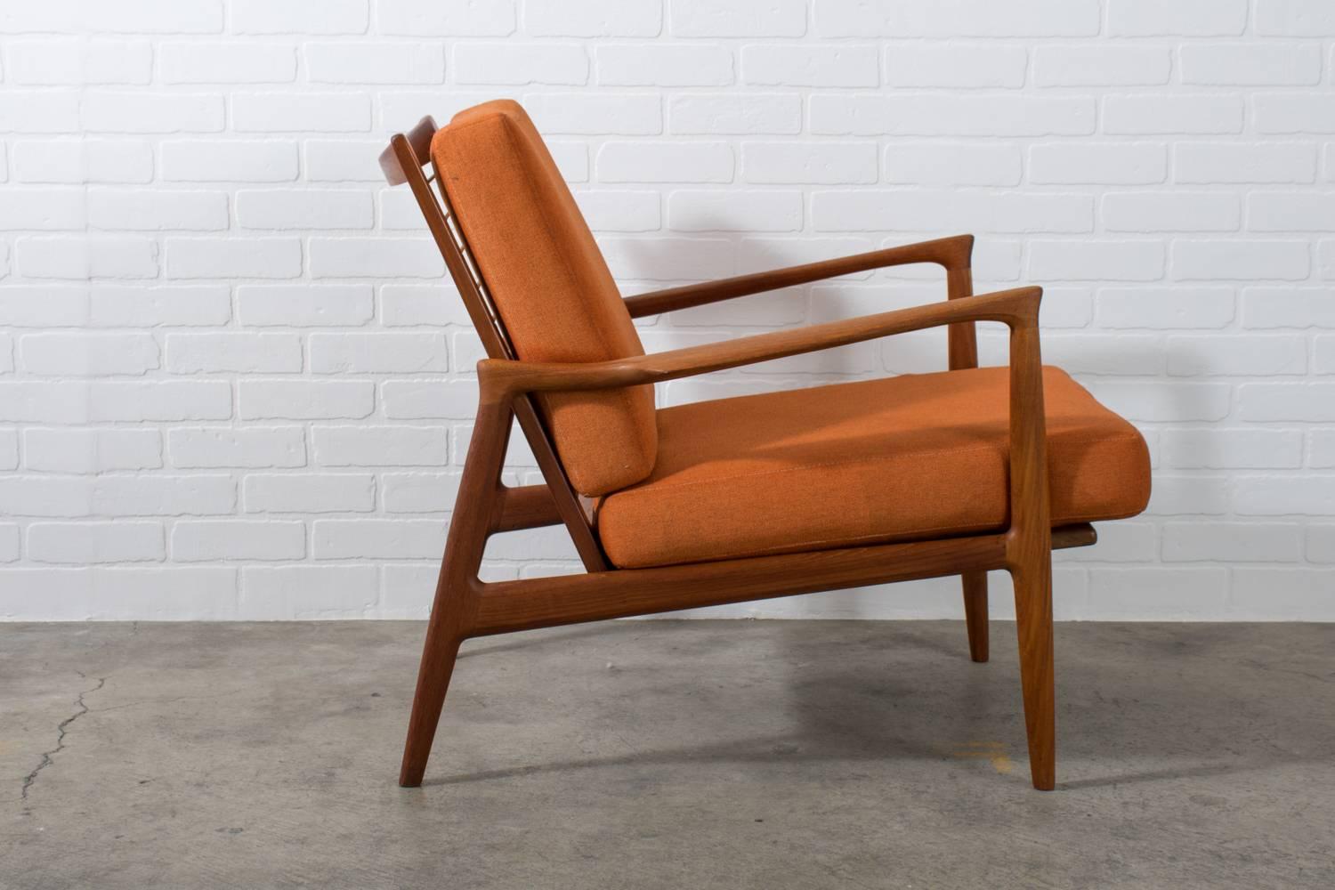 This Danish modern teak lounge chair by Ib Kofod-Larsen for Selig has beautiful curves. New straps. Original orange upholstery.