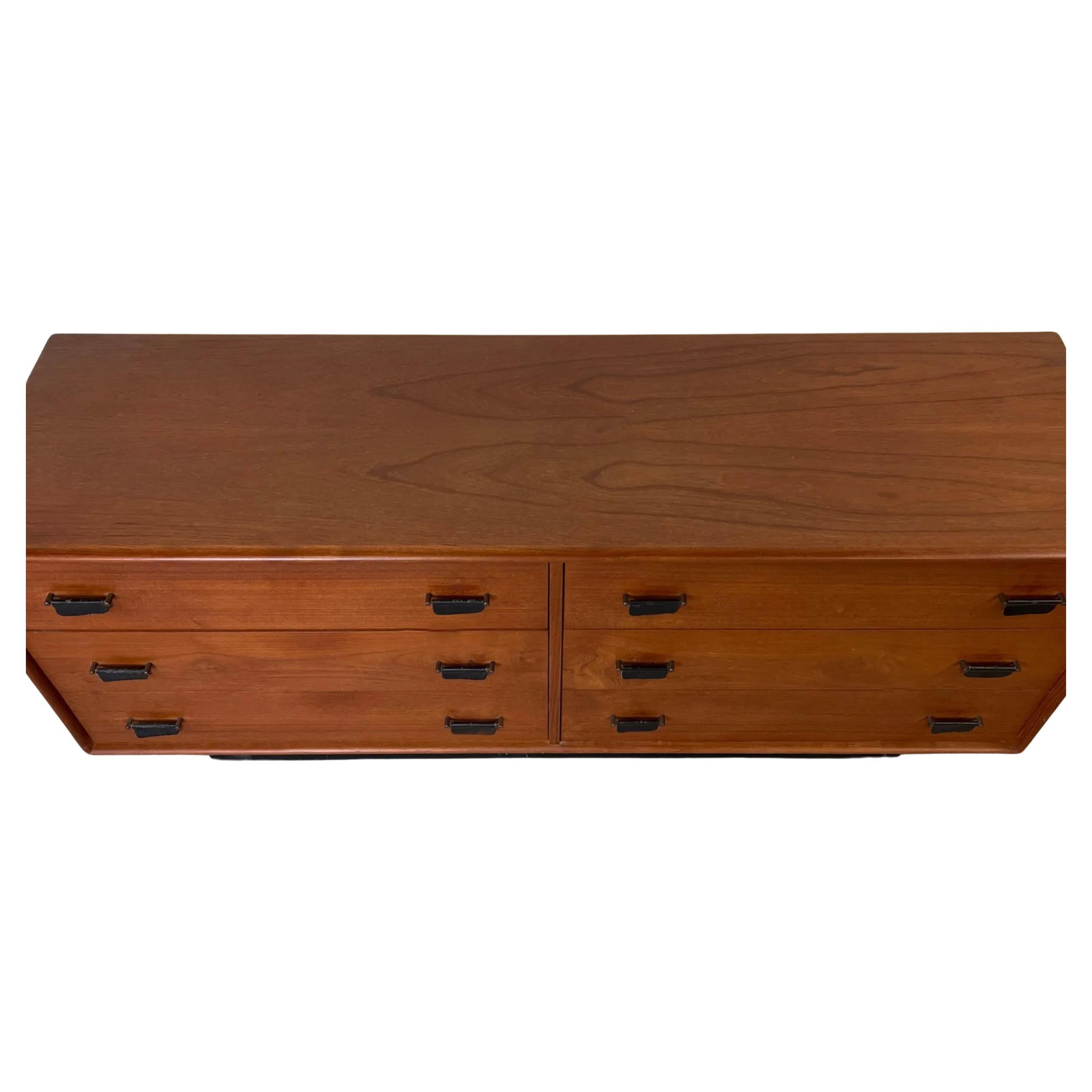 Mid Century Scandinavian Modern Teak low 6 drawer dresser with leather pulls and Black Lacquer plinth base. Very unique Teak Dresser or Credenza with hanging leather pull handles. Solid wood drawer construction with dovetail joints. Clean dresser in