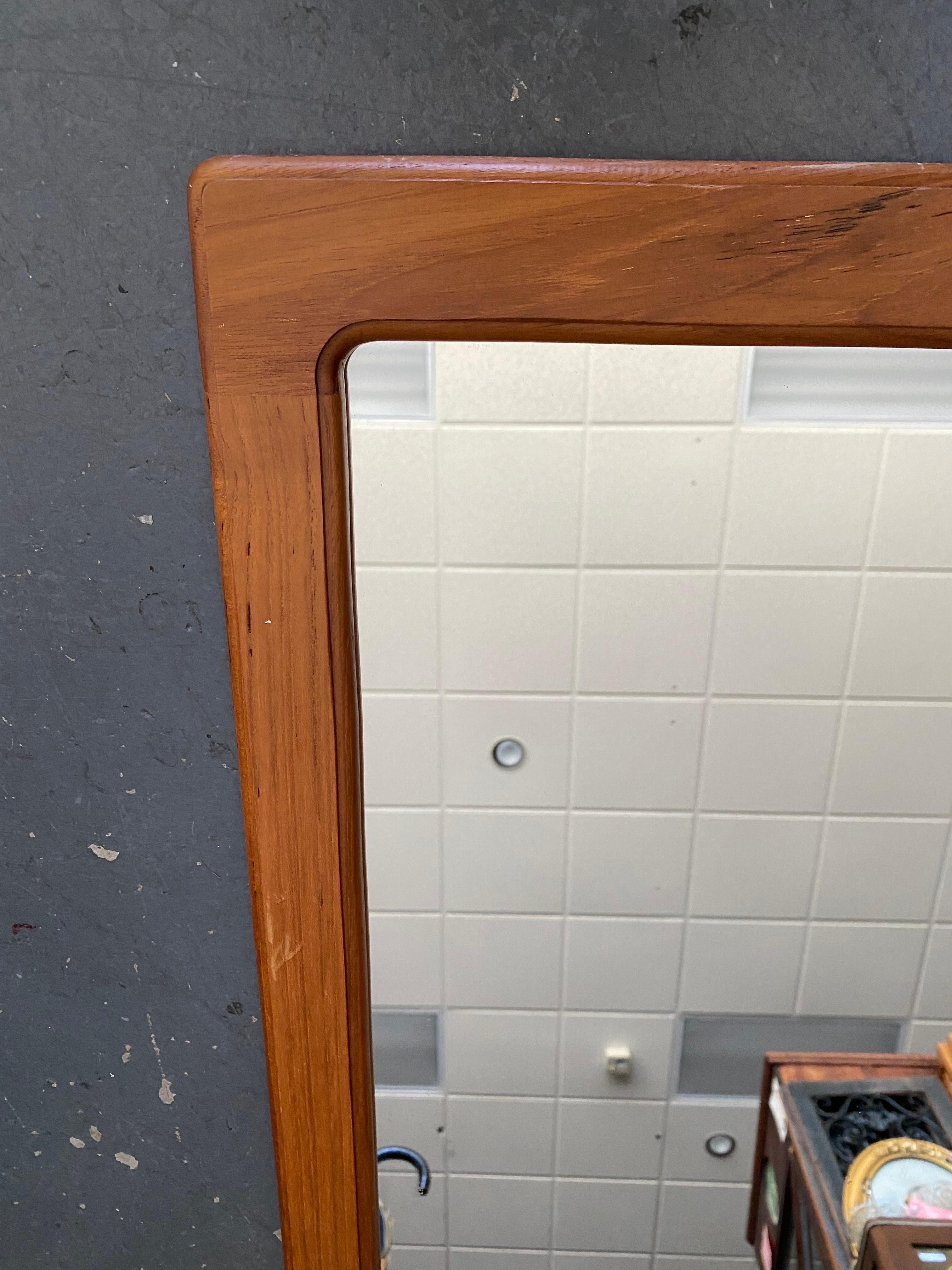 Beautiful Mid-Century Modern Danish teak wall mirror by Pedersen & Hansen. A compact mirror that combines function and style wherever displayed. Unique piece, don't miss out.

This mirror is in very good condition; the glass is scratch and crack