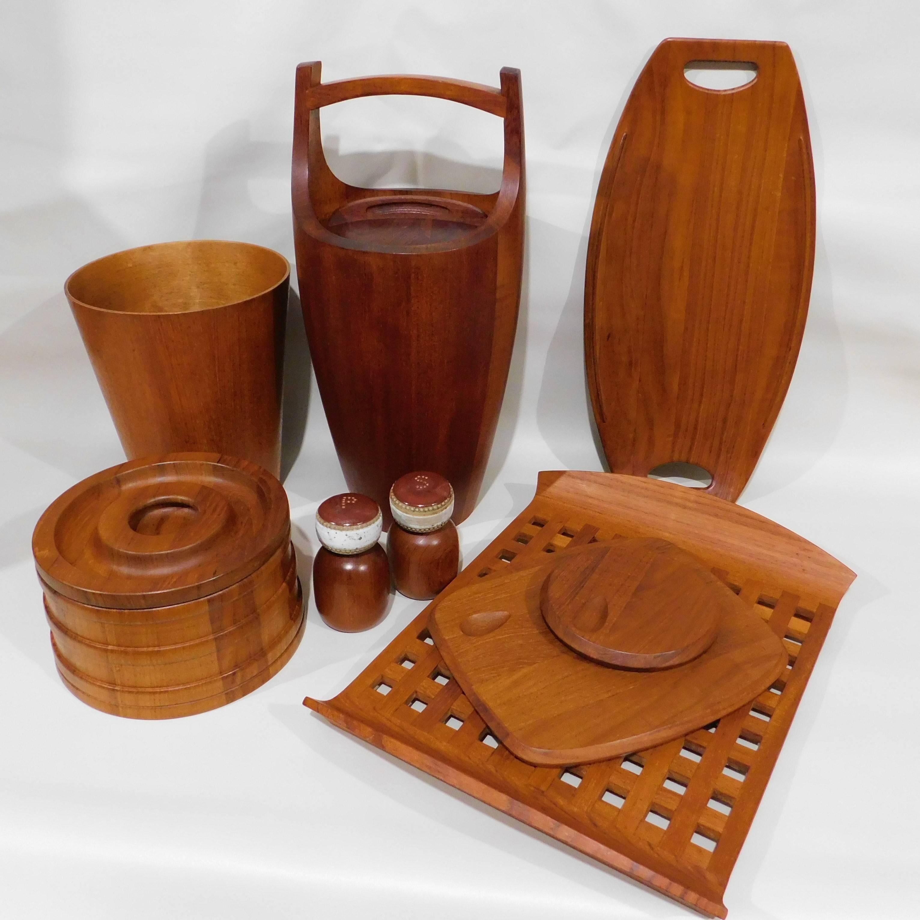 This nine-piece Mid Century teak set includes
-2 Jens Quistgaard ice buckets, measuring 20 inches high x 8.5 inches round and 5.5 inches high x 9 inches round. 
-2 Jens Quistgaard serving trays, 2 inches high x 20.5 inches long x 9.88 and 2.75