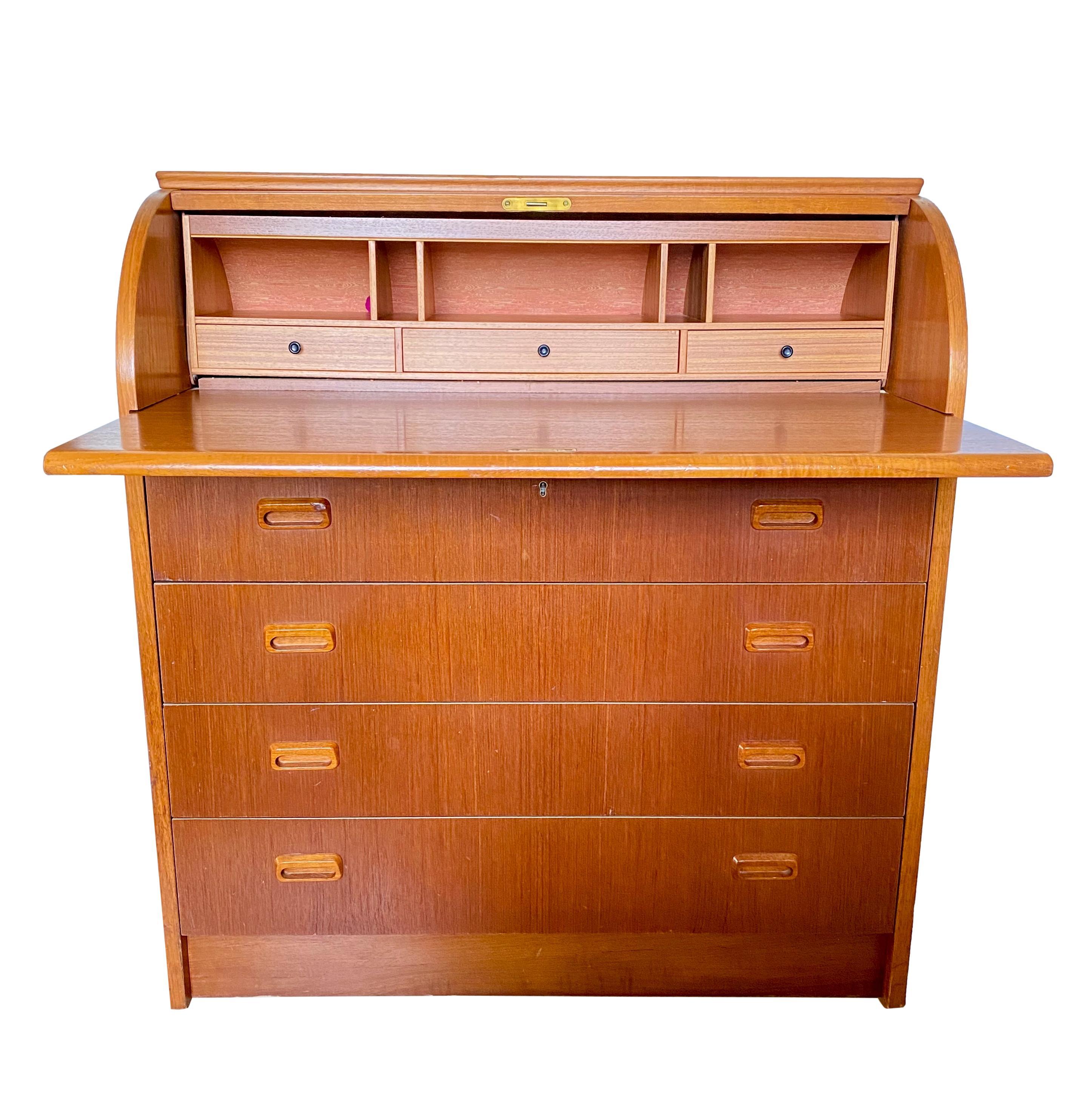 A vintage 1960's Swedish modern teak roll-top desk/bureau. Featuring a roll-up top, extendable desk surface, five storage cubbies, three upper drawers and four lower drawers with sculpted recessed handles.

Dimensions: 35.5