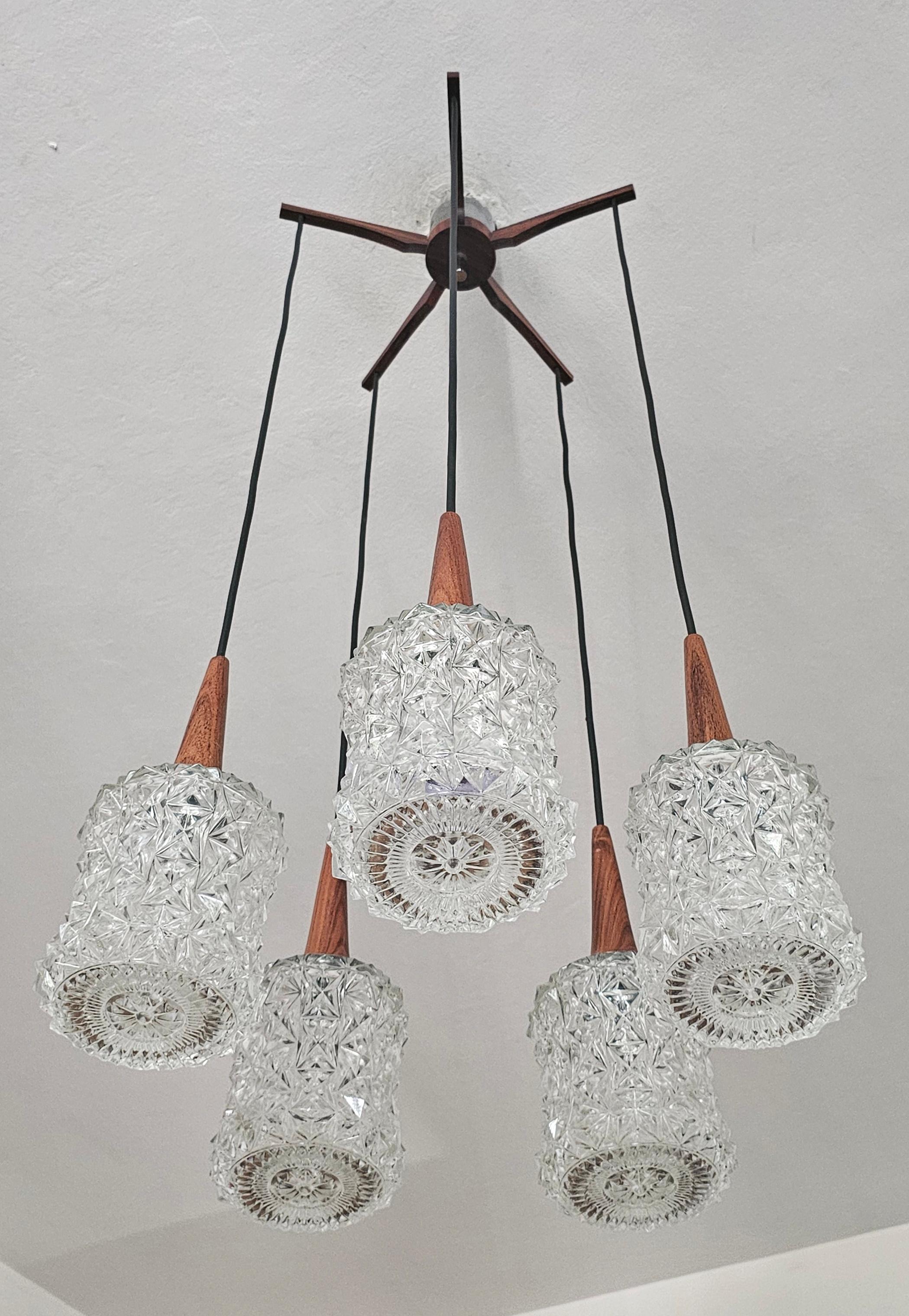 In this listing you will find a gorgeous and rare Mid Century Modern 5-Arm Spider or Cascade Chandelier. It features crystal shades, with teak accent and rosewood fixture. Cables could remain in the same height or get shorten to create a cascade.