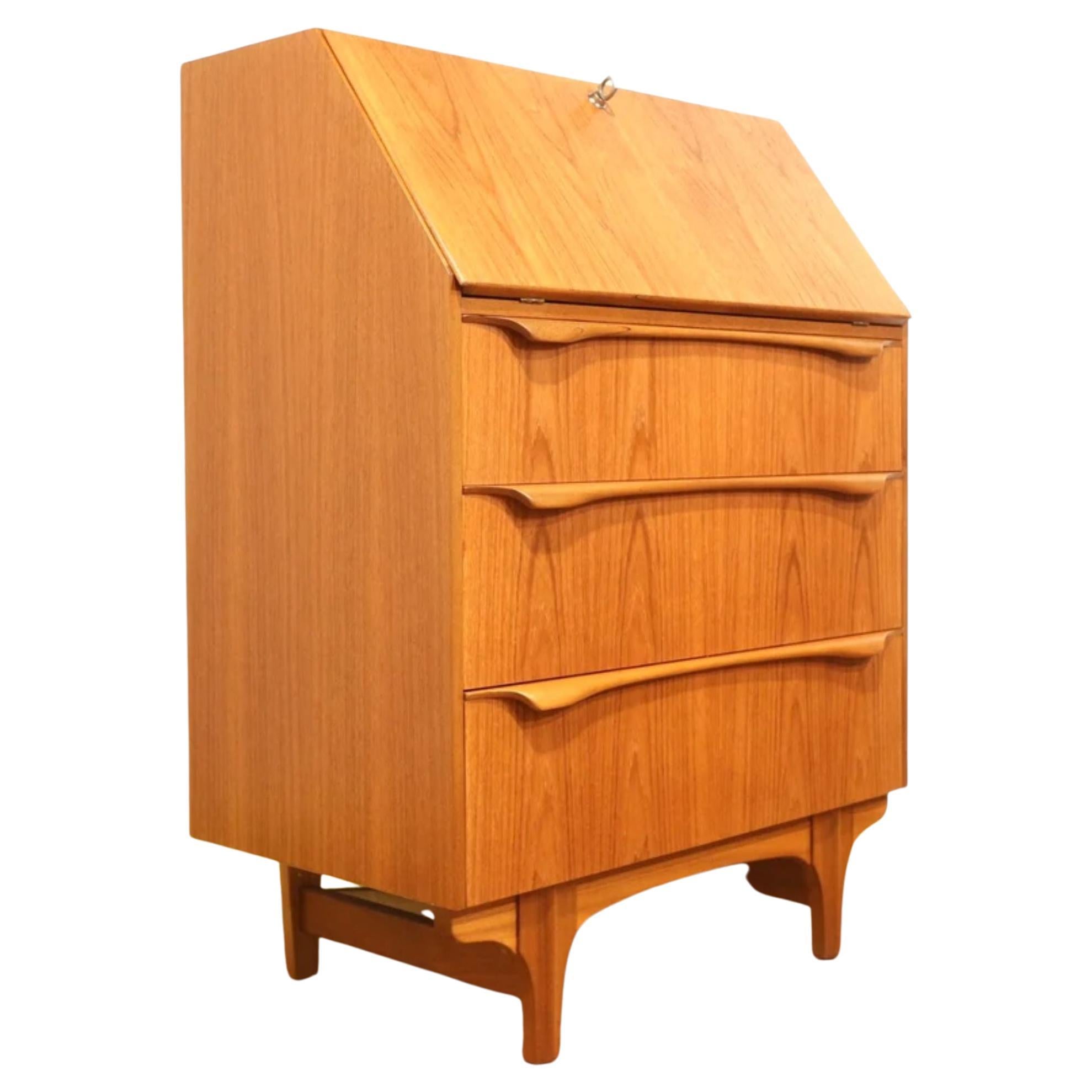 Mid-century teak bureau by Sutcliffe of Todmorden Furniture (S Form). UK made c1960s. Great for small spaces and perfect for working on a laptop or as a writing desk. There are three large drawers underneath a pull down work surface all set on short