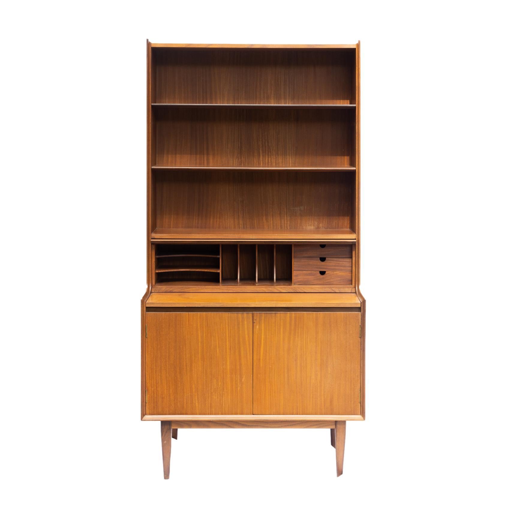 Mid-Century Modern Teak Bookcase, with three bookshelves, above a solid teak, fitted desk, with two storage cabinets below, on a stretcher base, Danish, ca. 1960.  
 