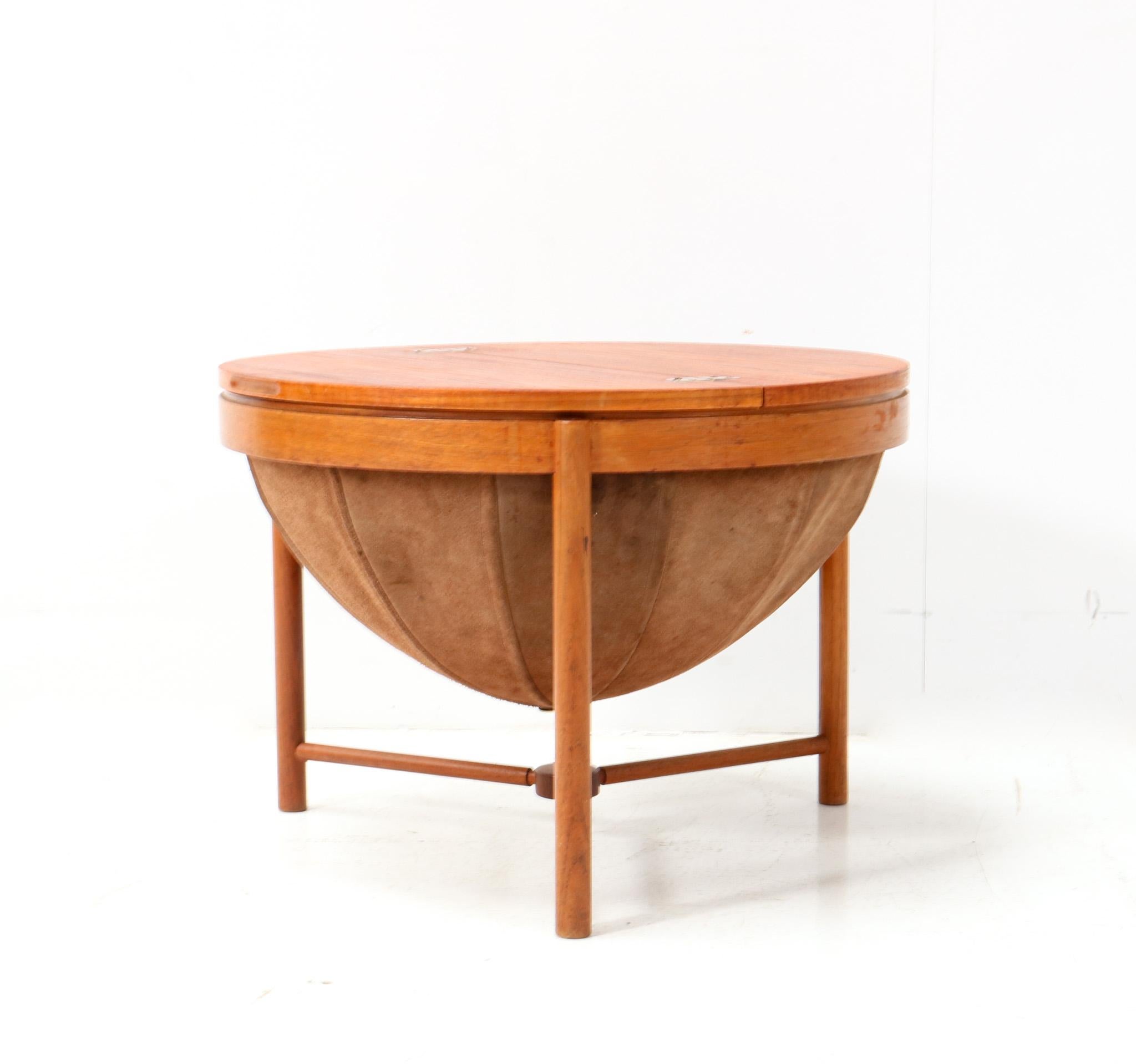 Stunning and elegant Mid-Century Modern sewing table or side table.
Design by Rolf Rastad and Adolf Relling for Rasmus Solberg.
Striking Norwegian design from the 1960s.
Solid teak base with original solid teak top.
Original leather basket and