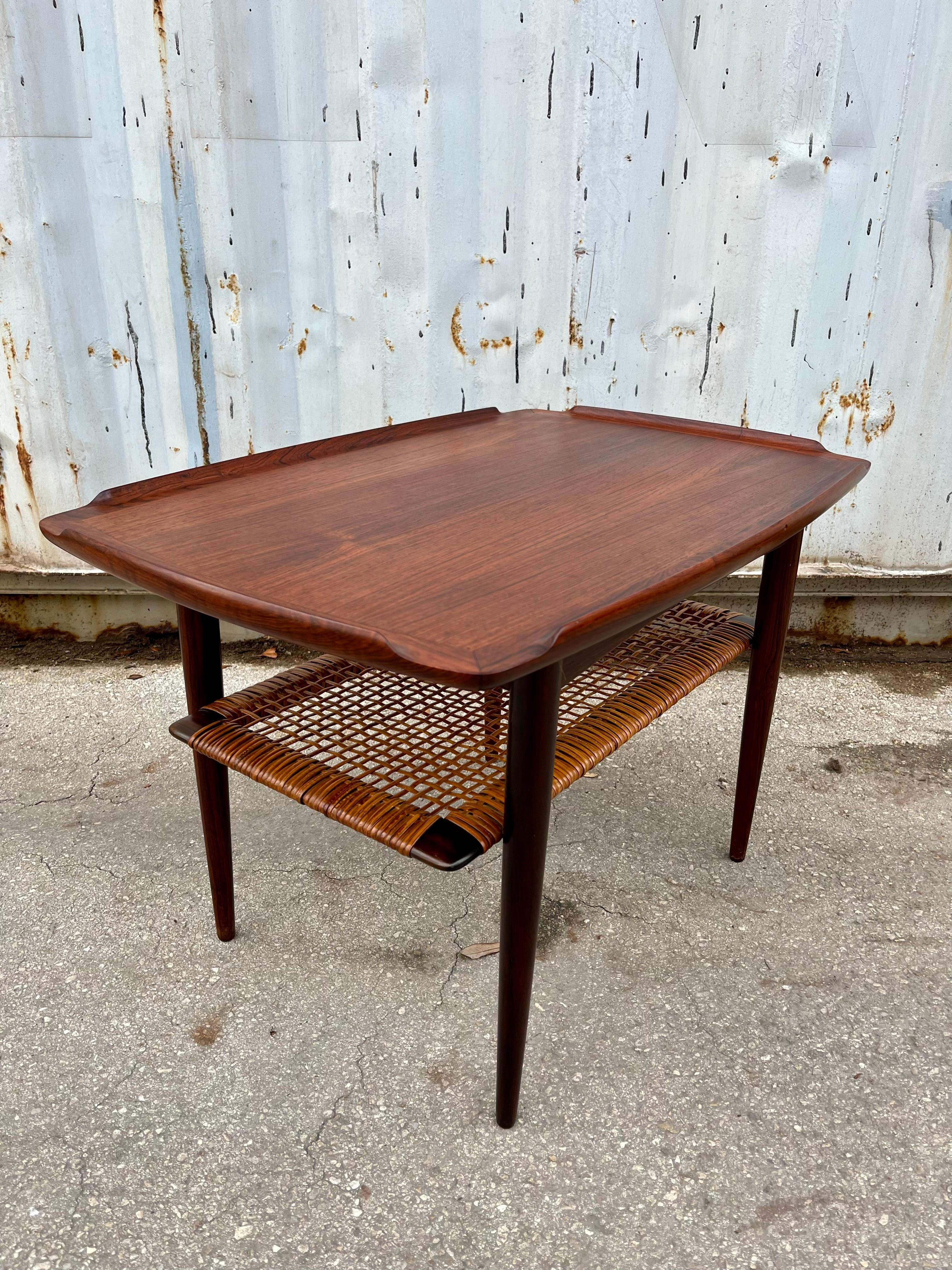 Vintage Mid Century Modern Teak Side Table by Poul Jensen for Selig, Denmark. C 1960s
Features a sleek Mid century Modern Scandinavian Design with sculpted edges, and a caned under shelf. 
In excellent condition with minor signs of wear consistent