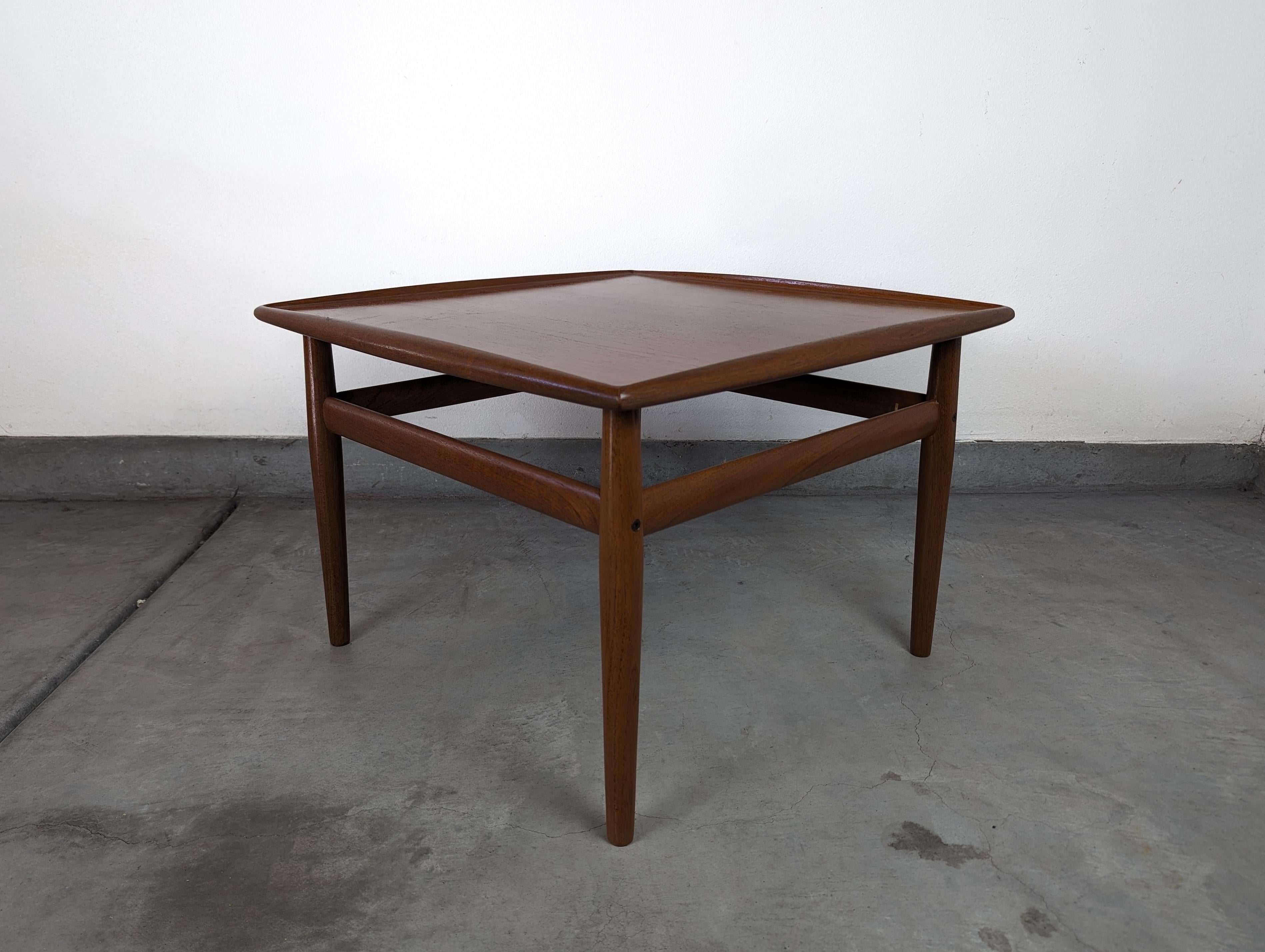 Voici une superbe table d'appoint vintage en teck de la célèbre designer danoise Grete Jalk pour Glostrup Møbelfabrik, datant des années 1960. Cette pièce remarquable de l'histoire danoise servira non seulement d'élément fonctionnel dans votre