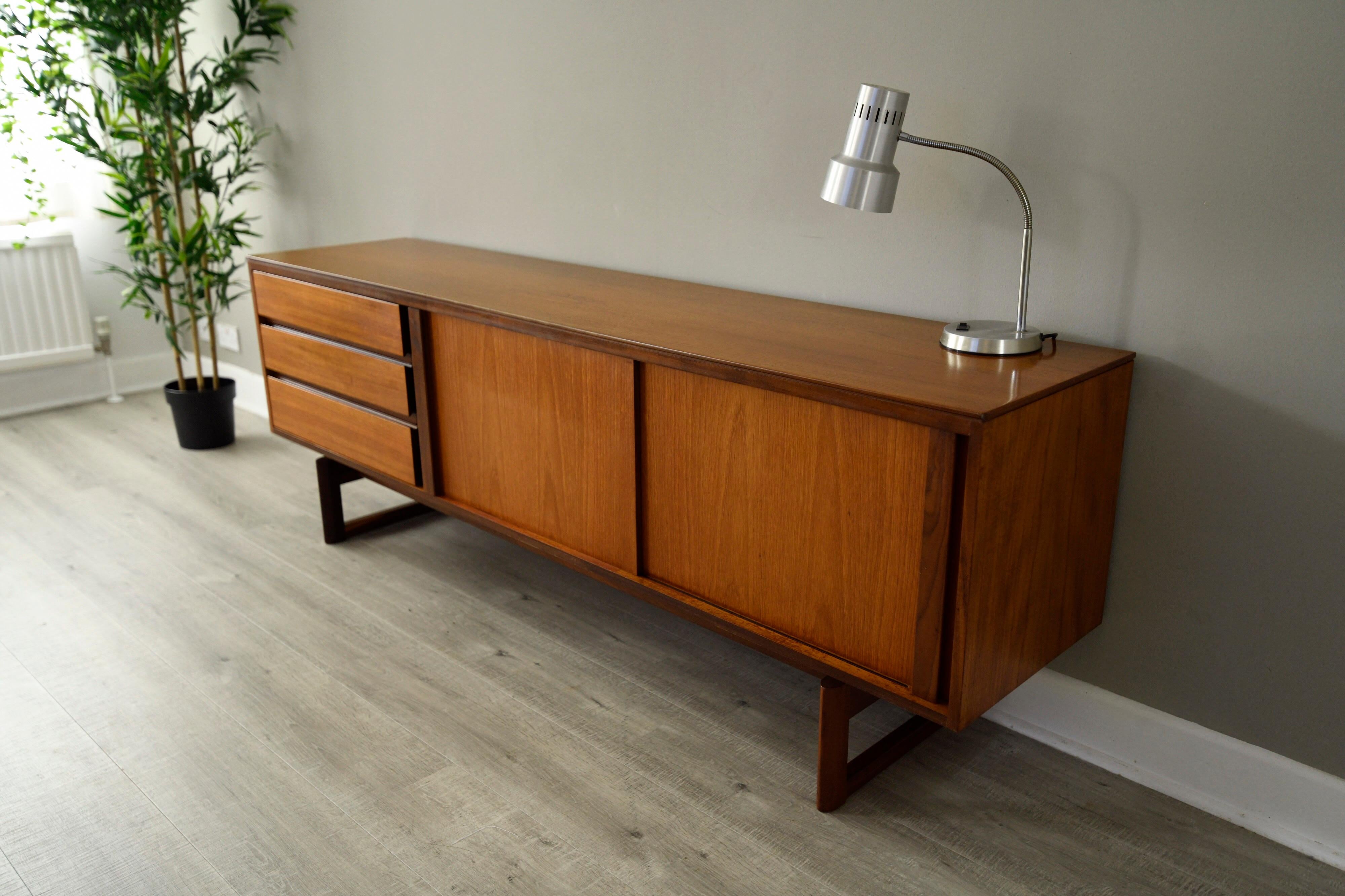 A stylish and strong linear form in this midcentury Classic teak sideboard by British furniture maker White & Newton based in Portsmouth under the design direction of Arthur Edwards.