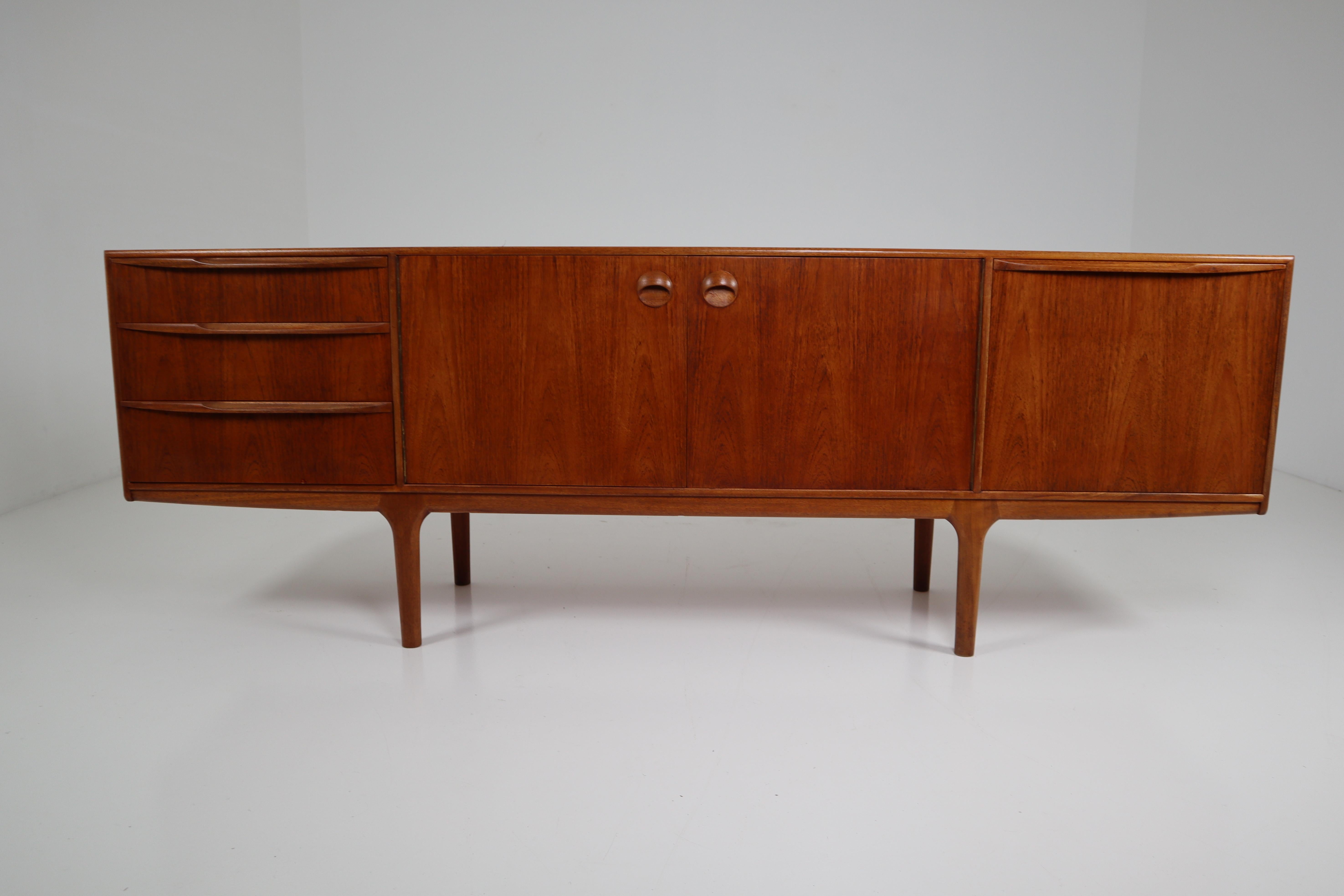This beautiful vintage modern sideboard features plenty of room for storage within its three drawers and two large storage compartments hidden by cabinet doors. Sleek two-tone design with unique carved pulls and tapered legs adding to the allure.