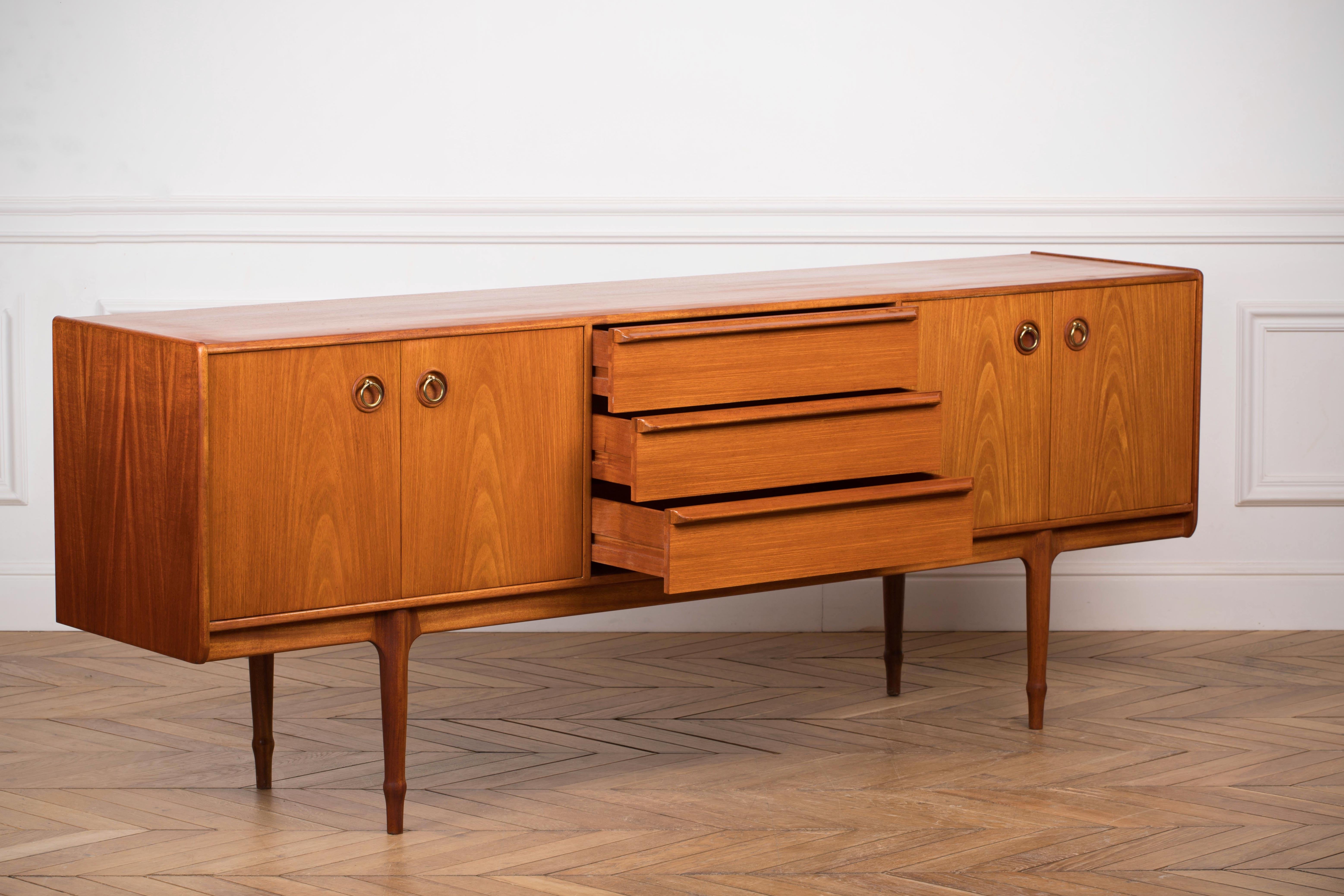 This beautiful vintage modern sideboard features plenty of room for storage within its three drawers and two large storage compartments hidden by cabinet doors. Sleek two-tone design with unique carved pulls and tapered legs adding to the allure.