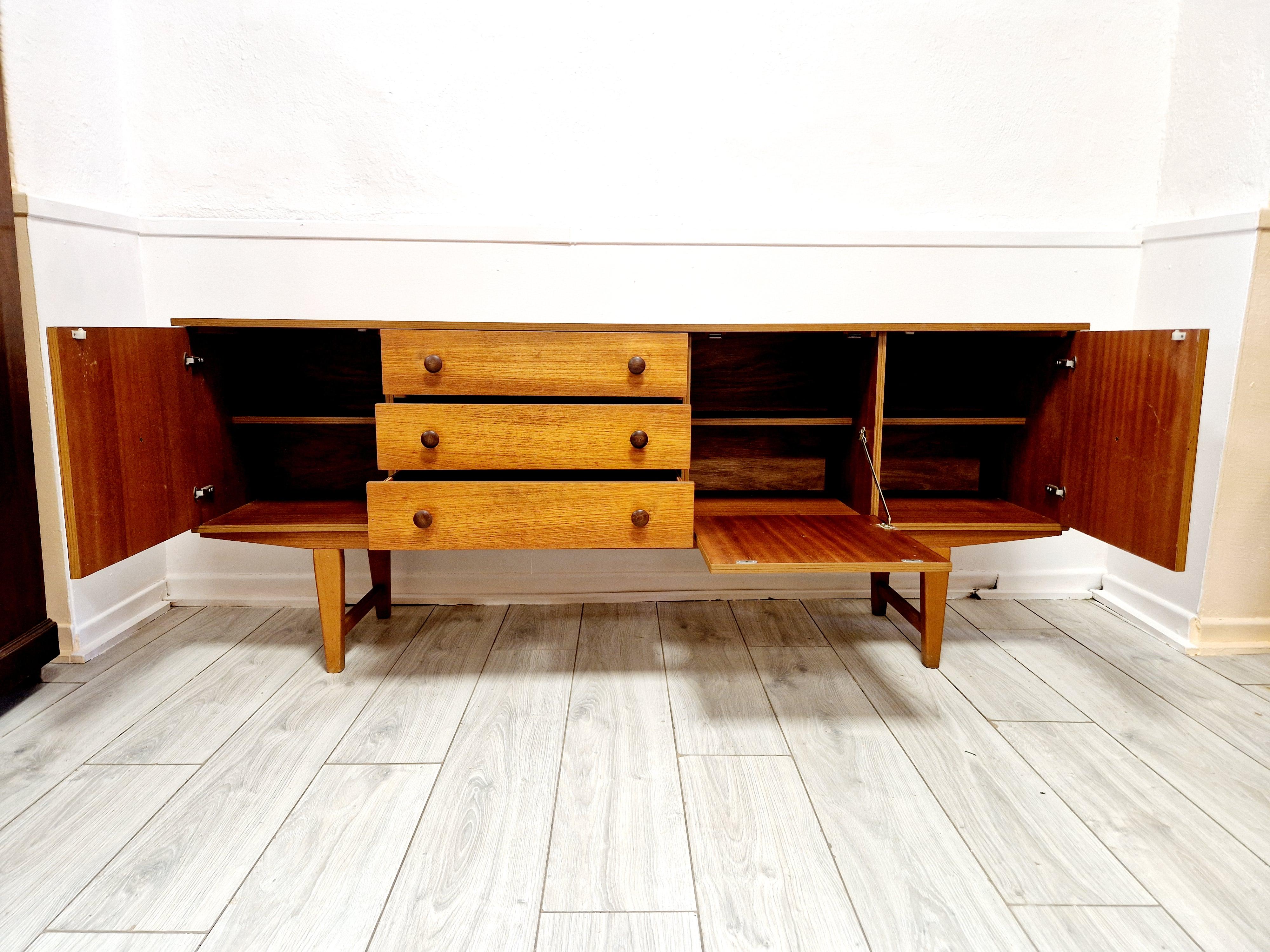 
Este aparador de teca de mediados de siglo, elaborado con elegancia retro, es un complemento sofisticado para cualquier interior. Con su robusta construcción de teca y su intemporal acabado laminado, aporta un toque de modernismo danés a tu hogar.