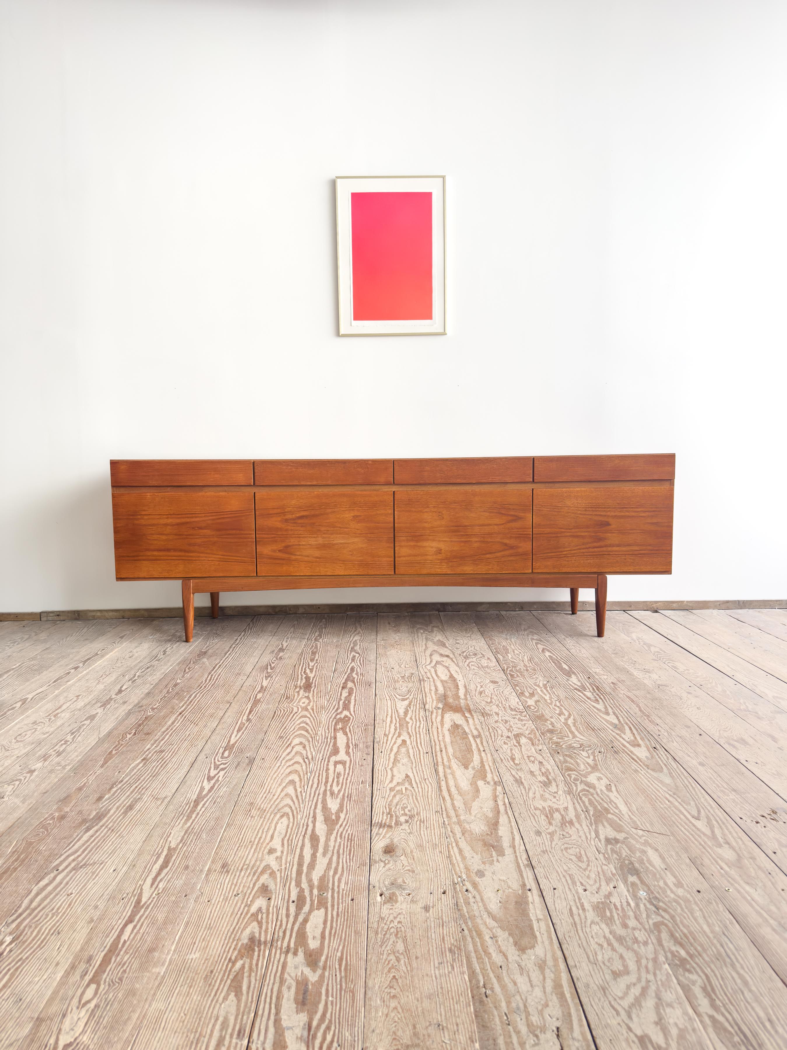Un aparador intemporal de la Modernidad de Mediados de Siglo, modelo FA-66, diseñado por Ib Kofod-Larsen y fabricado por Faarup Møbelfabrik en Dinamarca en la década de 1960. Fabricada en madera de teca ricamente veteada, la pieza combina líneas