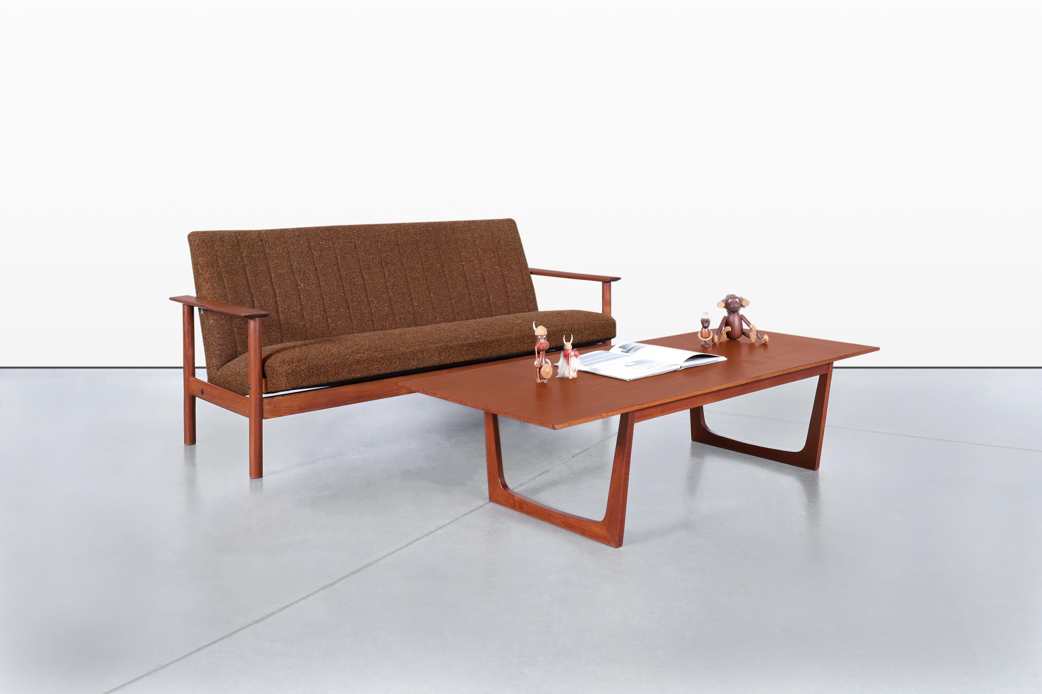 Scopri il fascino accattivante di questo straordinario divano in teak della metà del secolo scorso, un vero gioiello della Danimarca degli anni Sessanta. Questo pezzo incarna i principi del design scandinavo, fondendo la funzionalità con un'estetica