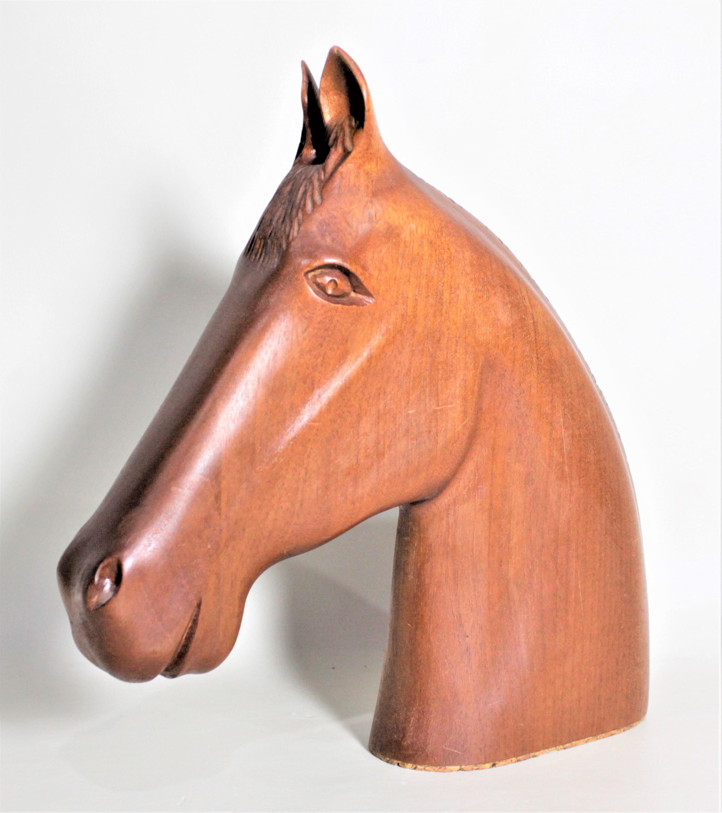 This solid teak stylized sculpture of a horse's head is unsigned but presumed to have been made in Scandinavia in circa 1970 in the midcentury style. The sculpture is carved out of a narrow solid block in a simplistic fashion giving it a streamlined