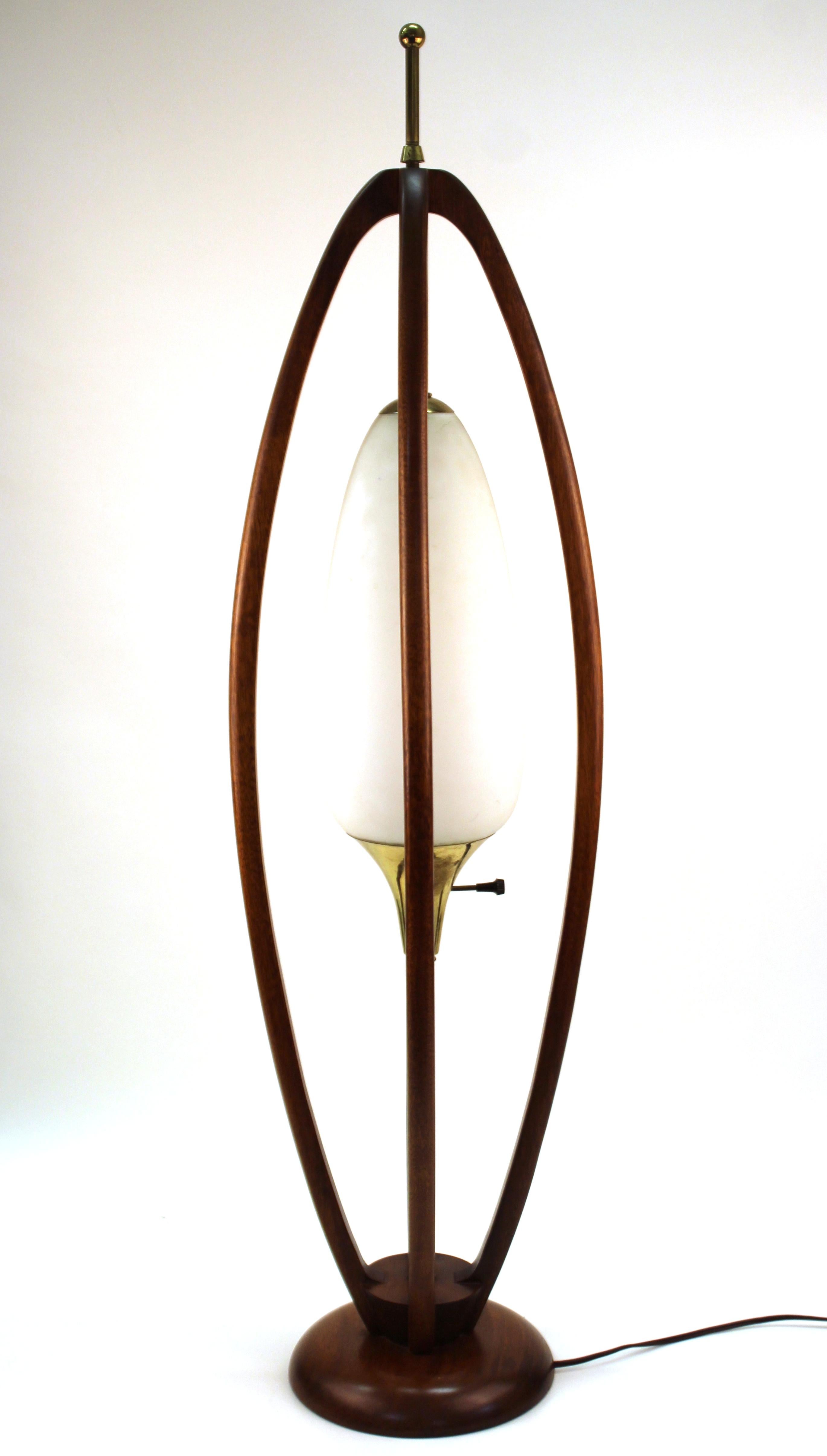 Mid-Century Modern table lamp made in teak with a glass shade, designed in the style of Modeline during the mid-20th century. The piece is in great vintage condition with some age-appropriate wear to the base and glass shade.
