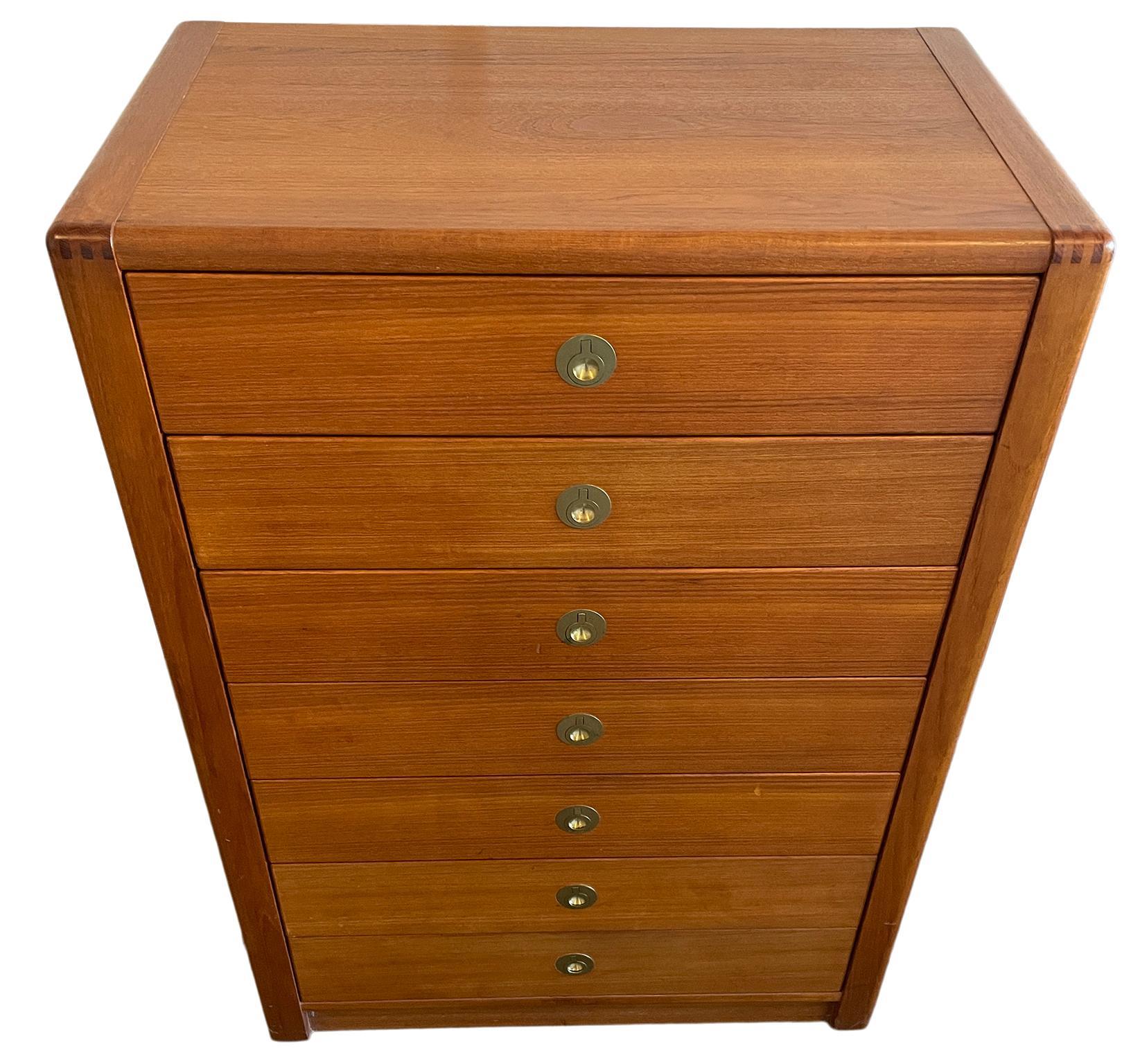 Comò alto a 7 cassetti in teak del Mid-Century Modern con tiranti in ottone. Tutti i cassetti sono puliti all'interno e all'esterno e scorrono senza problemi. Tiraggi a dita in ottone molto particolari. Situato a Brooklyn NYC.