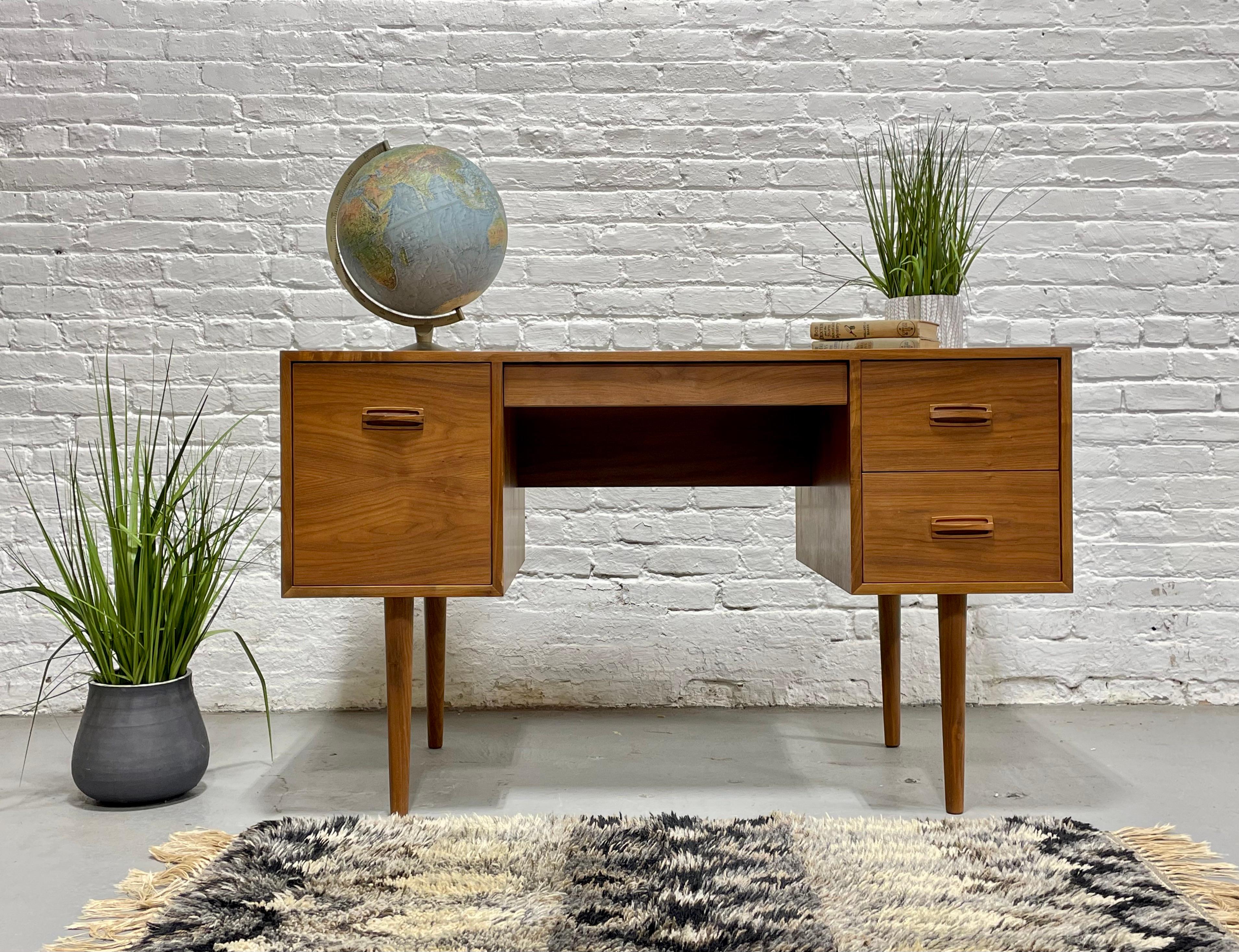 Teak Mid Century Modern Desk featuring a finished back, long sexy tapered legs and a wealth of storage space across multiple drawers, c. 1960's.  This stunning desk features the most gorgeous grains across each side. The back is finished is you wish