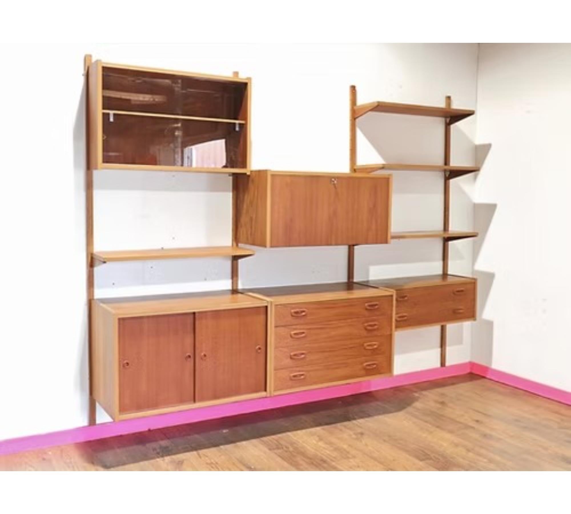 Scopri questo splendido sistema di stoccaggio a parete danese in teak PS da Mid Century Traders, dove l'eleganza senza tempo incontra la praticità. Questo capolavoro vintage promette fantastiche soluzioni di archiviazione, con un design fresco che