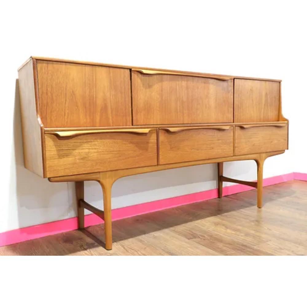 This Mid Century Modern Teak Vintage Sideboard Credenza by Sutcliffe S Form is the epitome of mid century style. Crafted by the renowned British furniture maker, Sutcliffe, this piece exudes quality and elegance. The sleek teak wood design and clean
