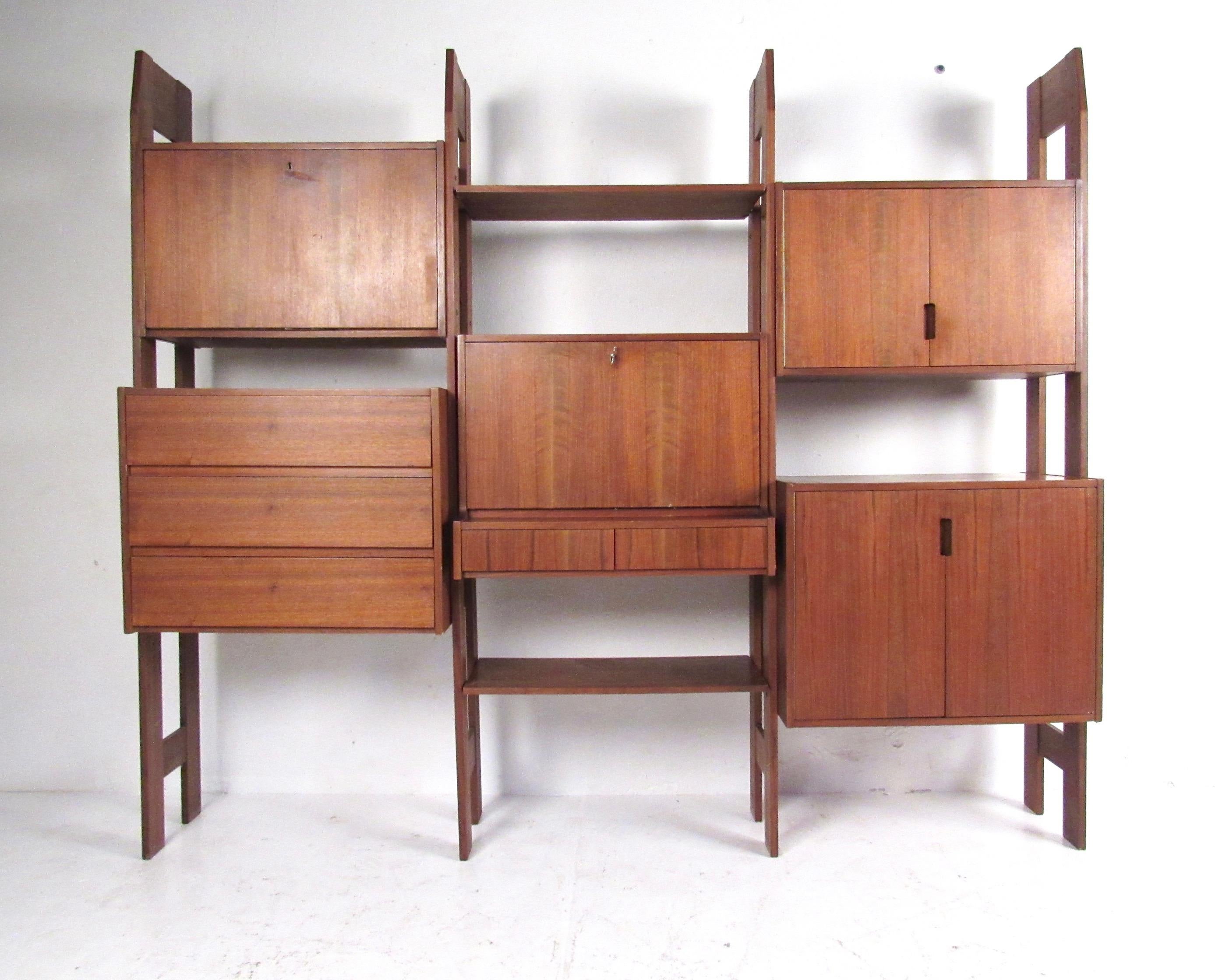 This large three bay wall unit features a versatile mixture of cabinet and shelf storage. Three-drawer dresser, drop front workspace, dry bar, and shelved cabinet storage can all be configured in the arrangement best suited to your home or business.