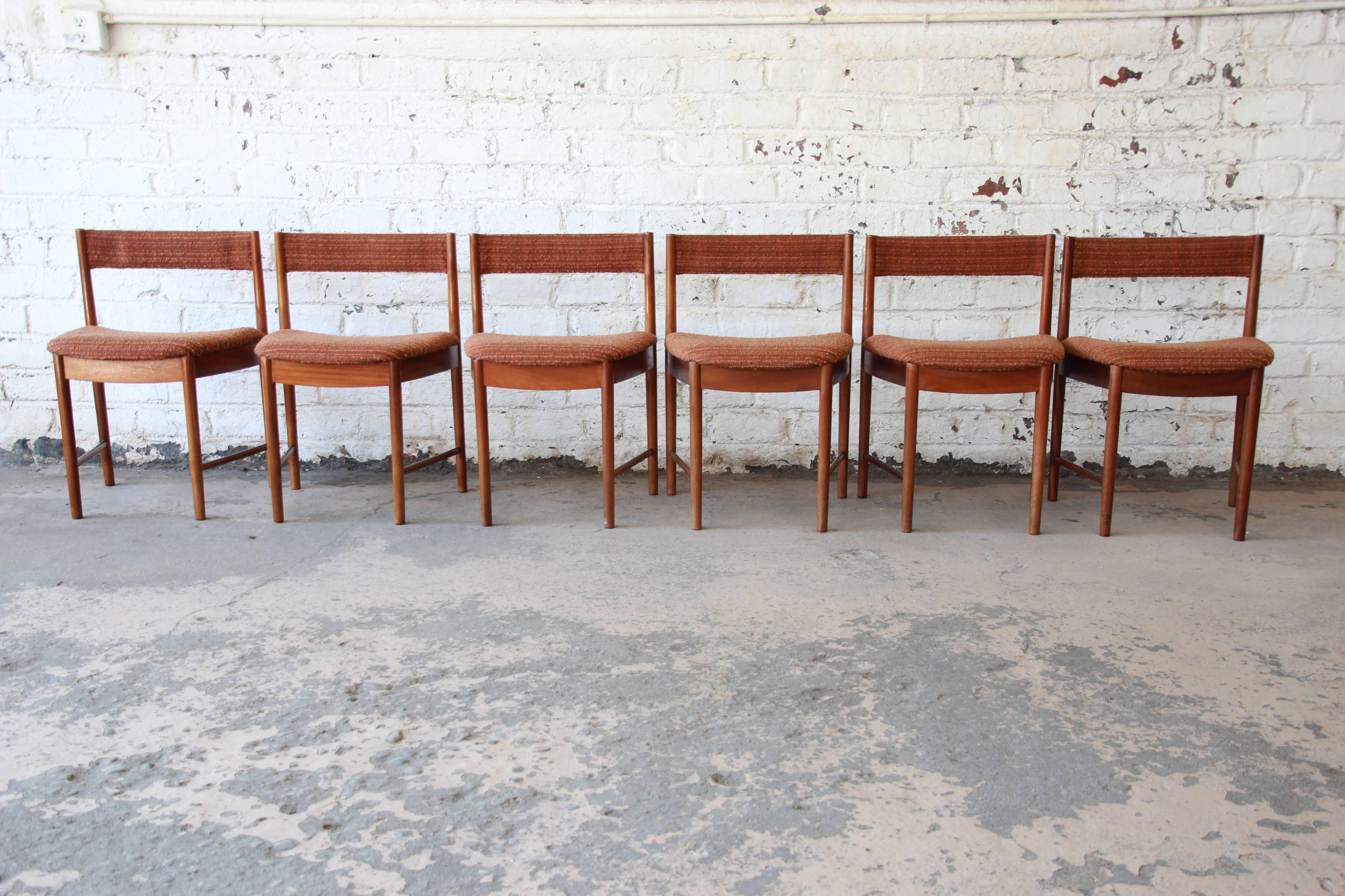 A beautiful set of six Mid-Century Modern teak dining chairs by G-Plan. The chairs feature solid teak wood construction and a unique wedge-shaped design. The burnt orange tweed upholstery is original and in very good condition. The chairs are sturdy