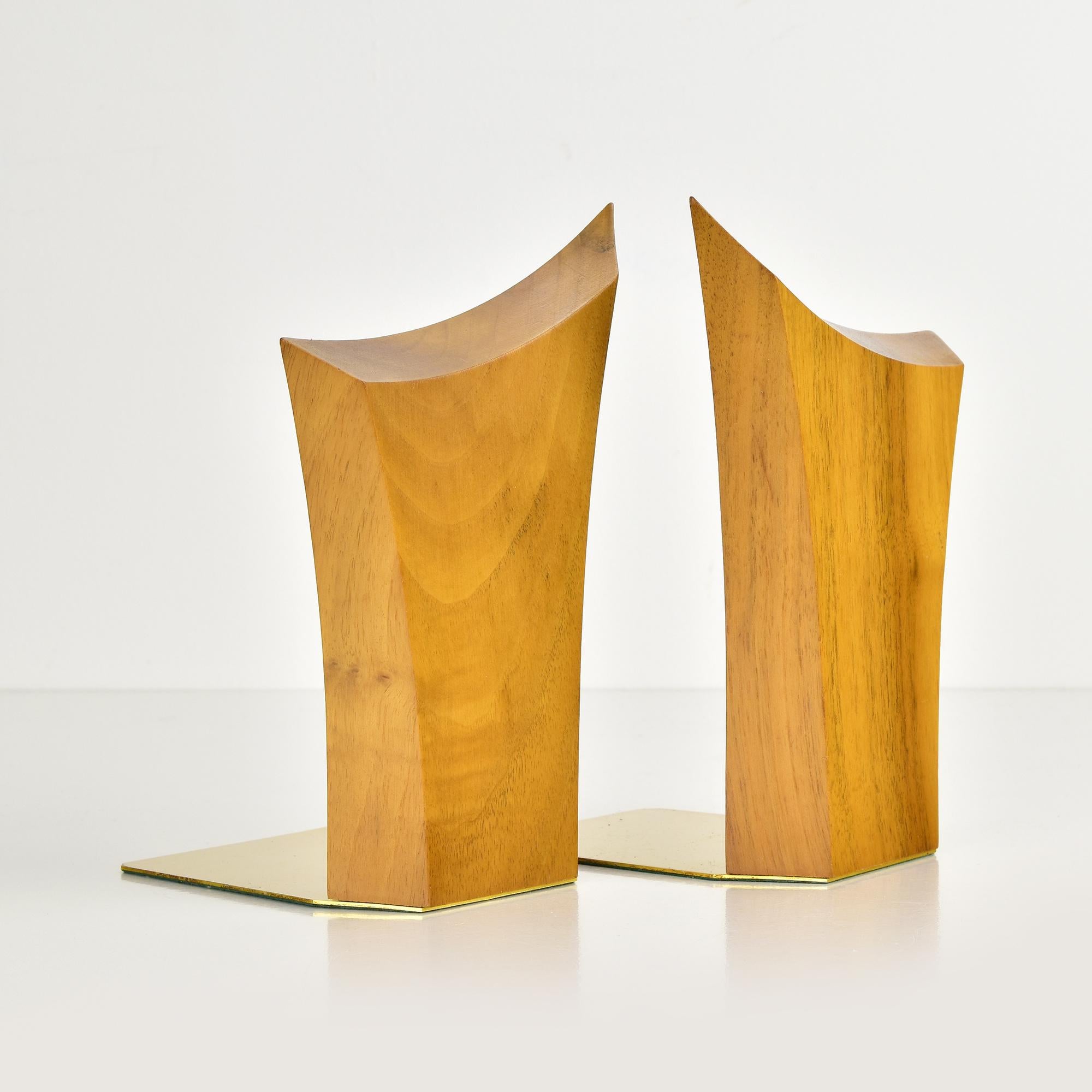 This pair of mid-century modern bookends showcases a striking Danish abstract brutalist design. Expertly crafted from solid teak wood, the pieces feature an elegant curved silhouette that blends natural aesthetics with minimalist form. The warm wood
