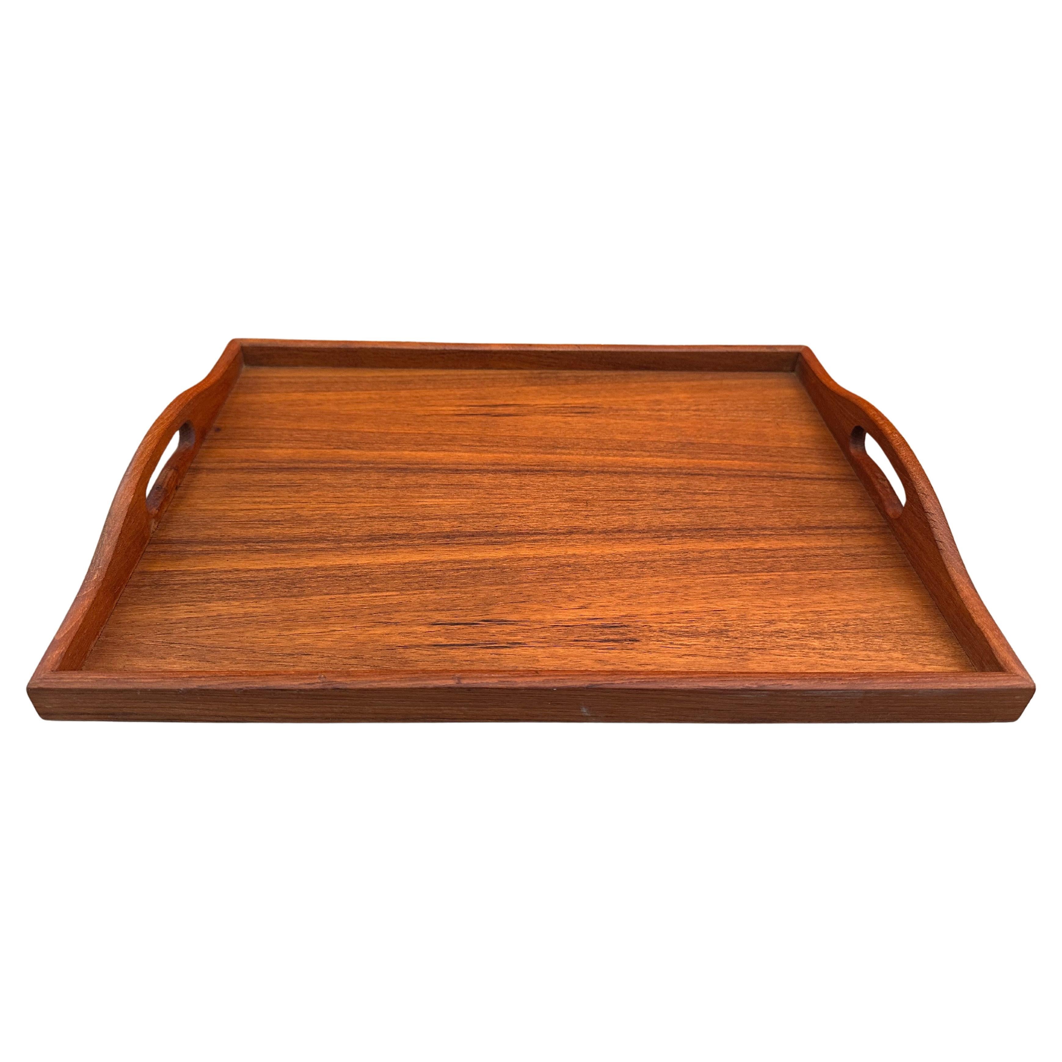Mid Century Modern Teak Wood Serving Tray with Handles, circa 1960s. Beautiful vintage teak tray with stunning wood grain. Minimalist design full of style.  Teak grain envelops the surface of the tray with easy to hold handles on each end for easy