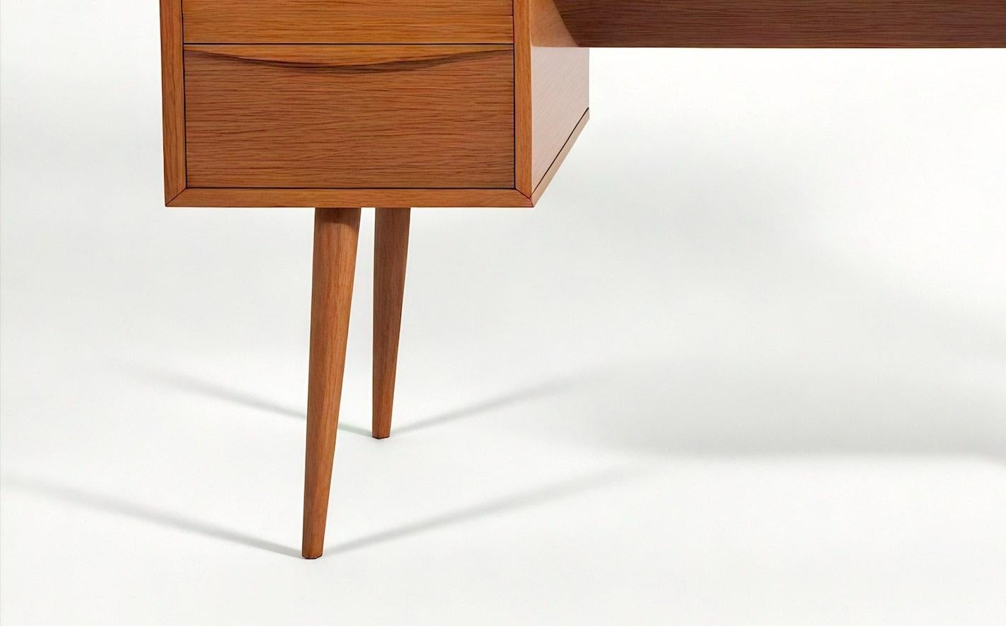 Capolavoro del design moderno di metà secolo, questo squisito scrittoio è realizzato in legno massiccio di teak e trasmette un'eleganza senza tempo e una maestria impeccabile. Rifinito a mano da abili artigiani, presenta un design a cassetti