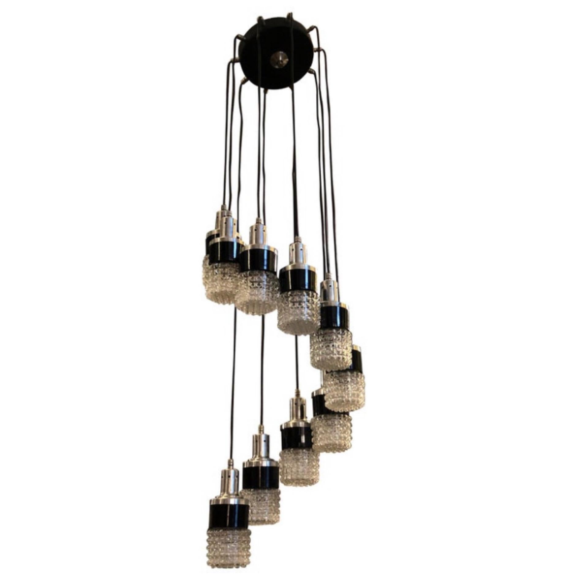 A cascading chandelier in the manner of Stilnovo designed and manufactured in Italy in the Seventies in perfect conditions. It works both 110-240 volts and needs ten regular e14 bulbs. It's a timeless and elegant lighting fixture that captures the