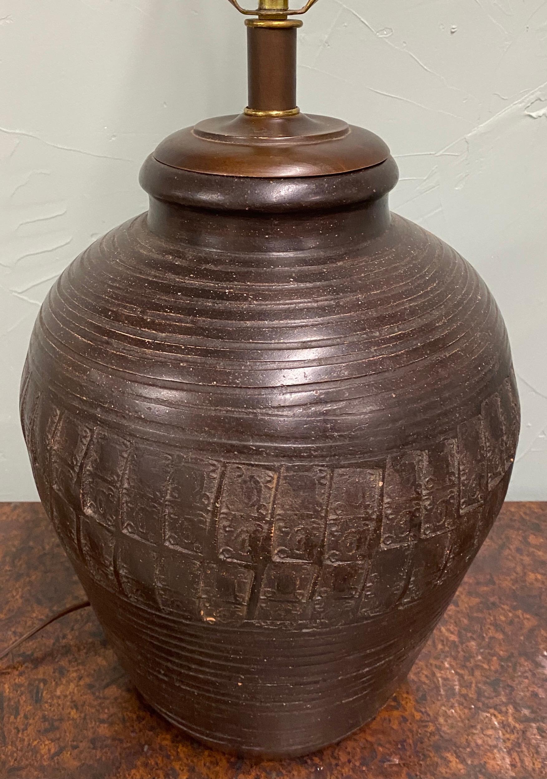 Mid-20th century urn style coffee glazed terracotta jar lamp, outstanding handcrafted stoneware with abstract circular and geometric decorative details. 
Lamp can be sold with or without lamp shade.$825 lamp only $125 Lamp shade.
Measures: 25