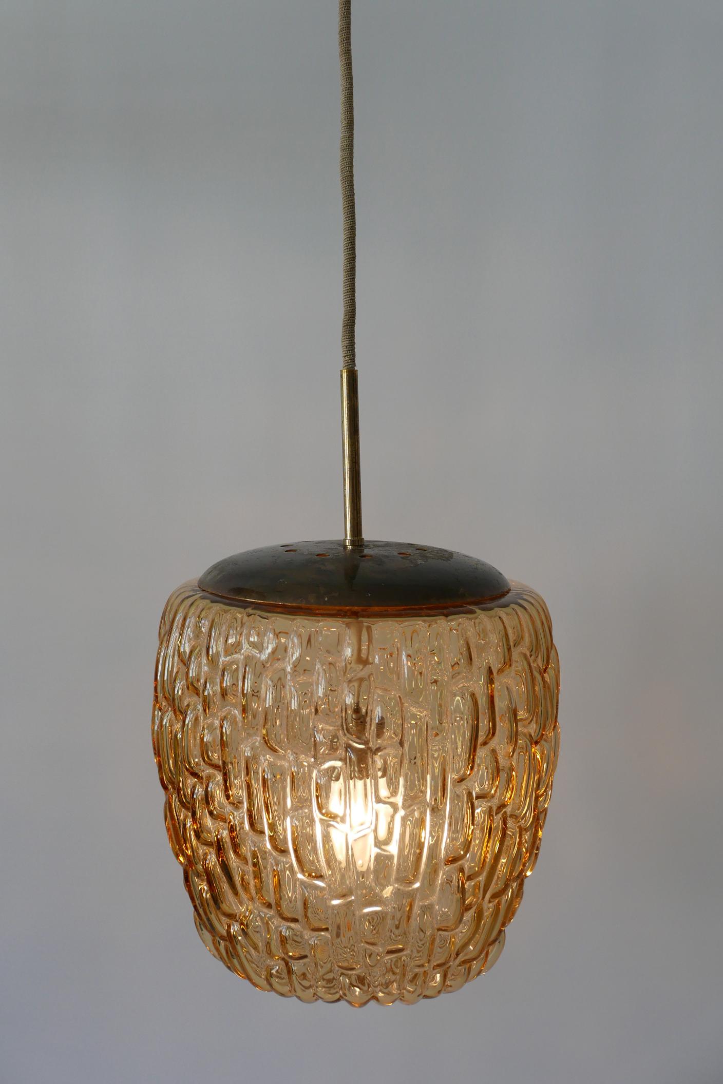 Exceptional and decorative Mid-Century Modern pendant lamp or hanging light. Designed and manufactured by Rupert Nikoll, 1950s, Austria.

Executed in thick honey colored blown glass and brass, it comes with 1 x E27 Edison screw fit bulb holder, is