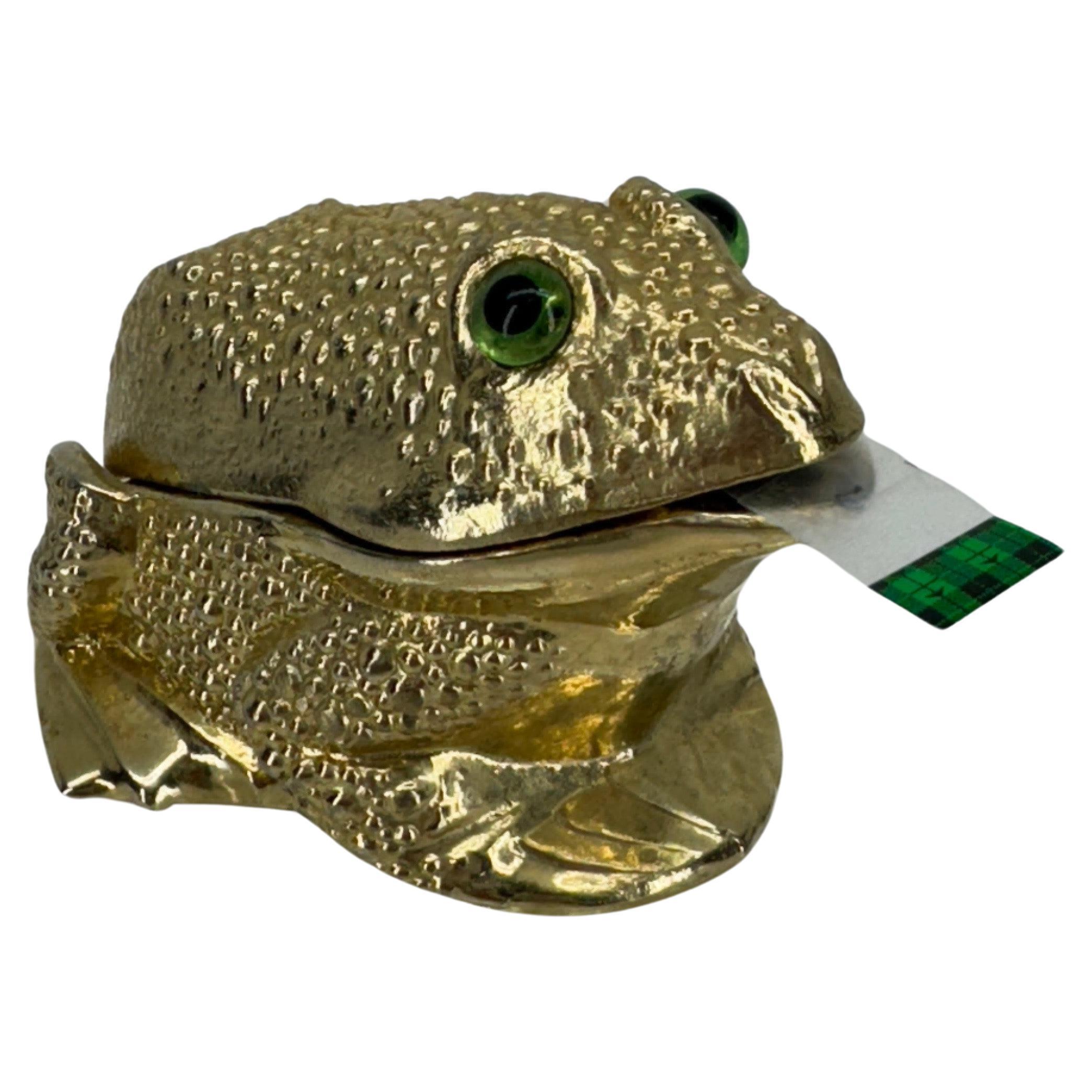 Textured Gold Tone Metal Frog Tape Dispenser, 1960's

This vintage two piece tape dispenser is from Ted Arnold Ltd. The charming frog with green glass eyes is stamped on the inside lid. This frog is a fantastic functional piece to add to a