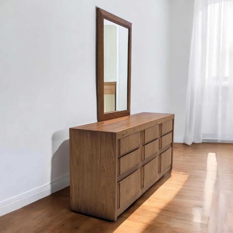Un elegante comò lungo in stile Mid-Century Modern realizzato in una ricca finitura color noce, caratterizzato da linee pulite e scultoree, un'abbondanza di contenitori e sottili tiretti a incastro che sottolineano l'estetica minimalista. Questo