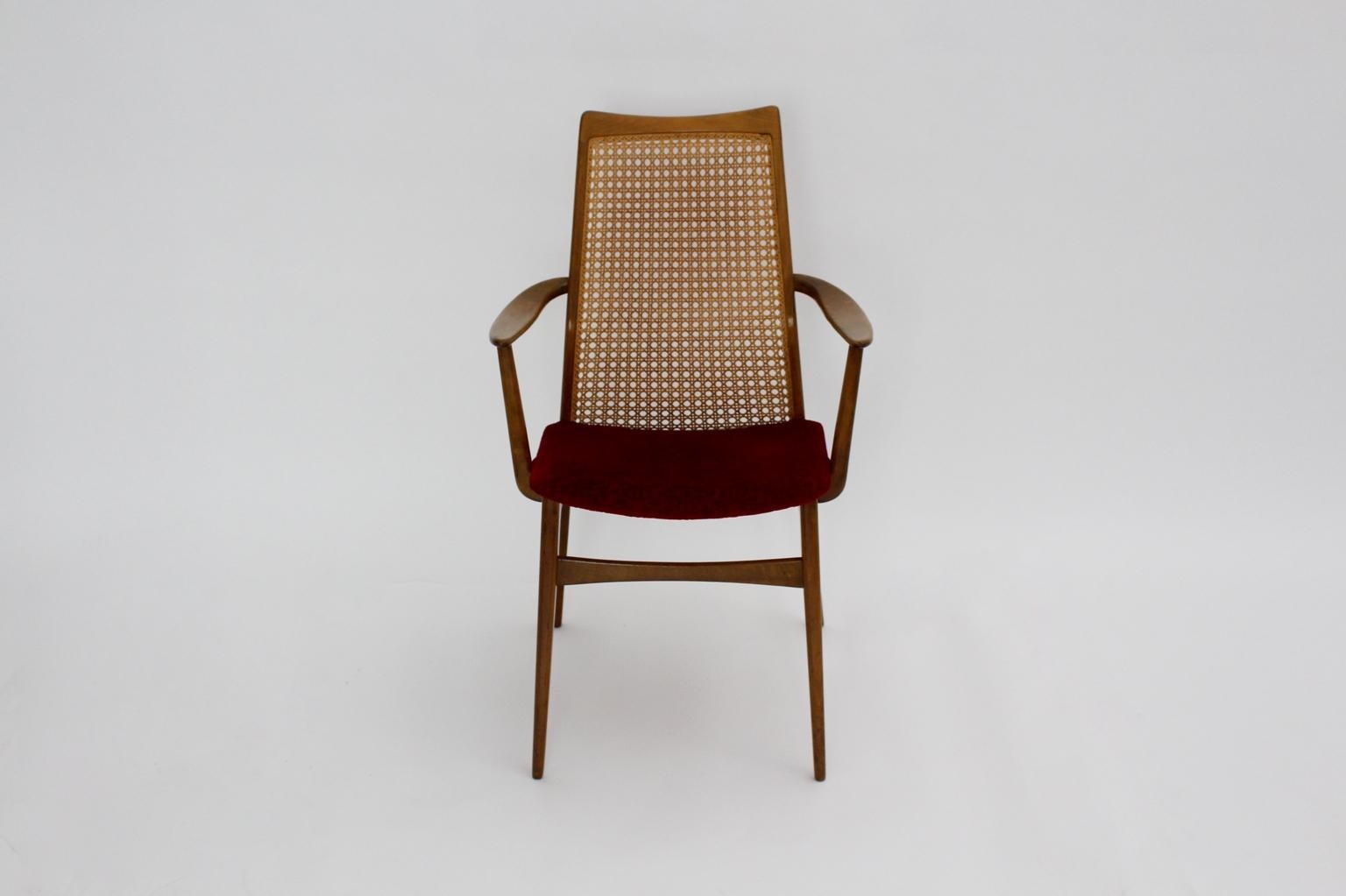 The armchair executed by Gebr. Thonet shows a label underneath the seat.
Also the beechwood armchair features a woven cane on the back. Furthermore the seat was covered with red fabric. Two curved armchairs provide the armchair with an elegant