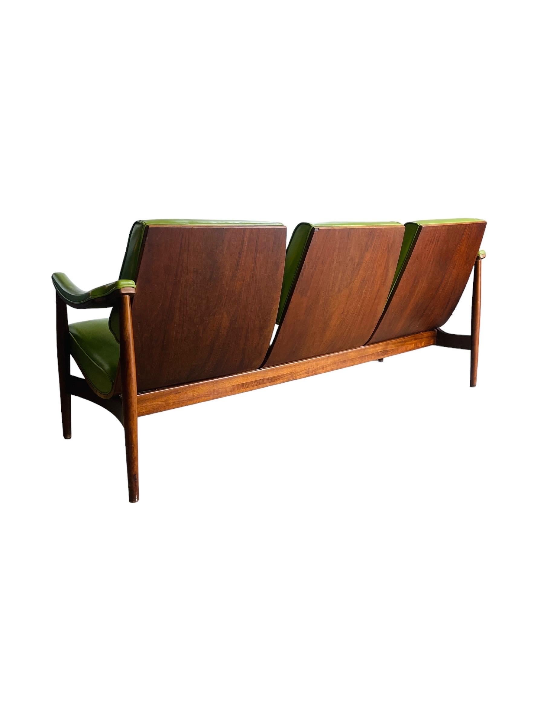 Immerse yourself in the vintage charm of this Mid-Century Modern Thonet sofa. Crafted with exquisite walnut bentwood, this sofa retains its original tag, indicating its authentic pedigree. While it shows minor stains on the right seat—a detailed
