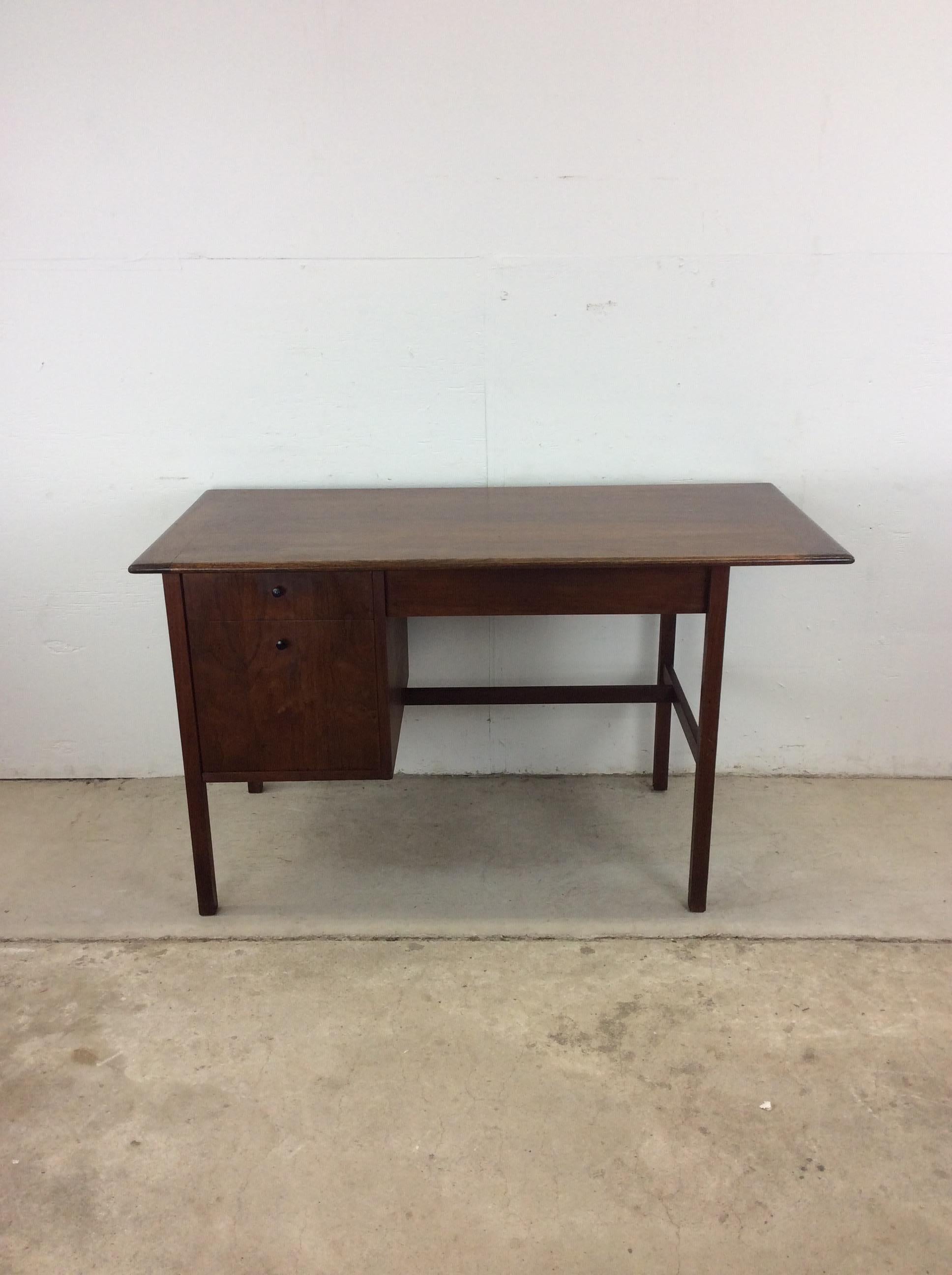 Ce bureau moderne du milieu du siècle présente une construction en bois dur, un placage de noyer avec une finition originale, trois tiroirs à queue d'aronde avec une quincaillerie peinte en noir, et de hauts pieds coniques.

Dimensions : 50.25w