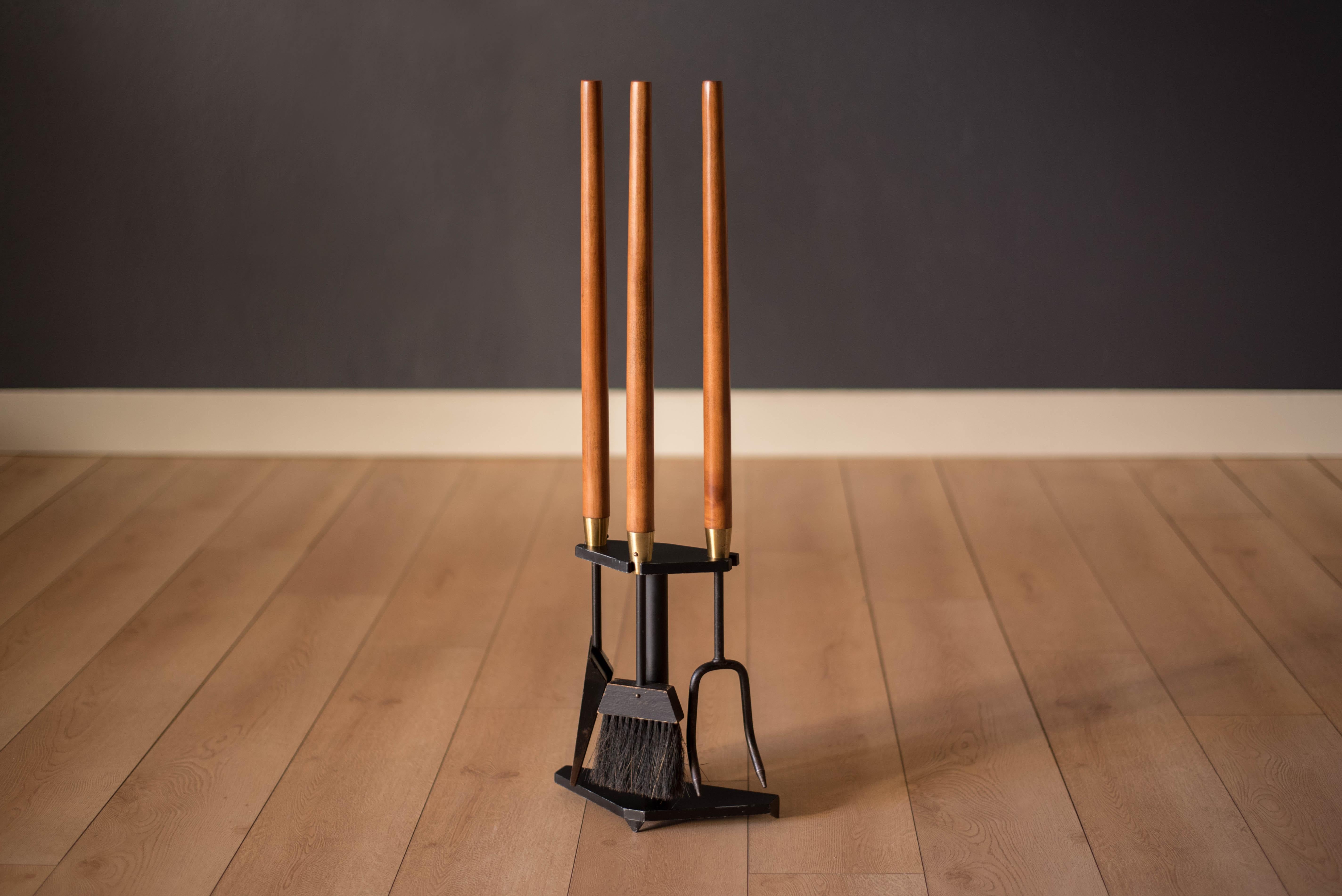 Vintage 3-piece fireplace tool set and floor stand by Seymour Manufacturing Co., circa 1960s. This set features sculpted wood handles with brass accents and a heavy cast iron base. Includes poker, shovel, brush, and floor stand.