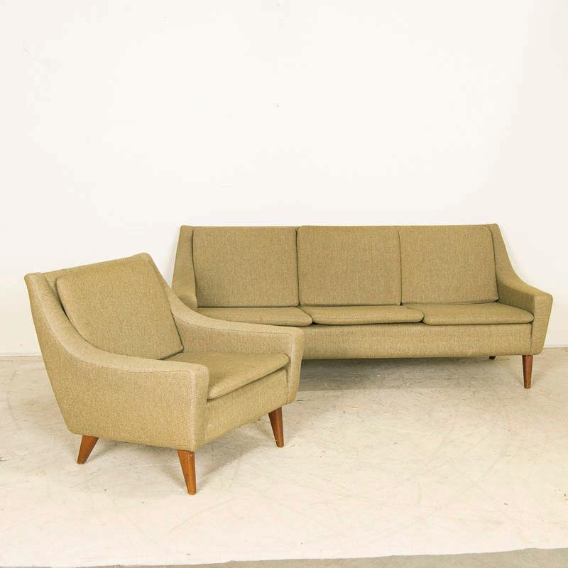 The sleek style of this Mid-Century Modern sofa and chair boasts the clean and simple lines that create a timeless look. The original light green wool fabric shows typical age-related wear with some stains and fading on the removeable cushions, but