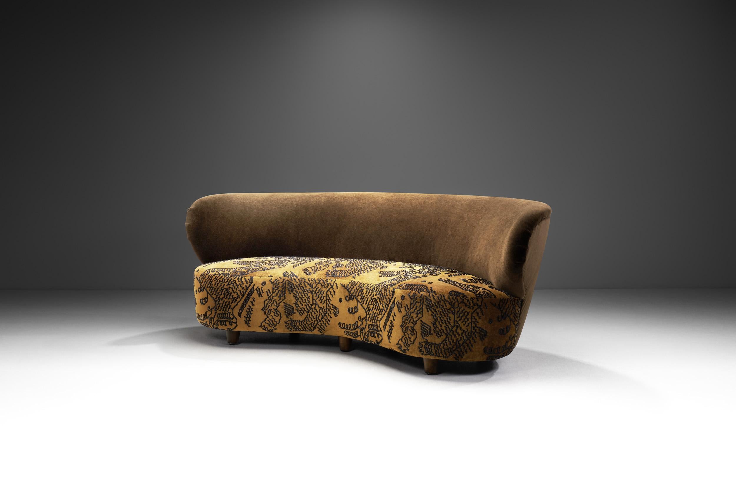 Dieses außergewöhnliche Dreisitzer-Sofa ist auf die bestmögliche Weise exzentrisch: mit einem großen, geschwungenen Korpus und einer einzigartigen Polsterung, die beide an den Art-déco-Stil der 1930er Jahre erinnern, aber auch die erkennbaren