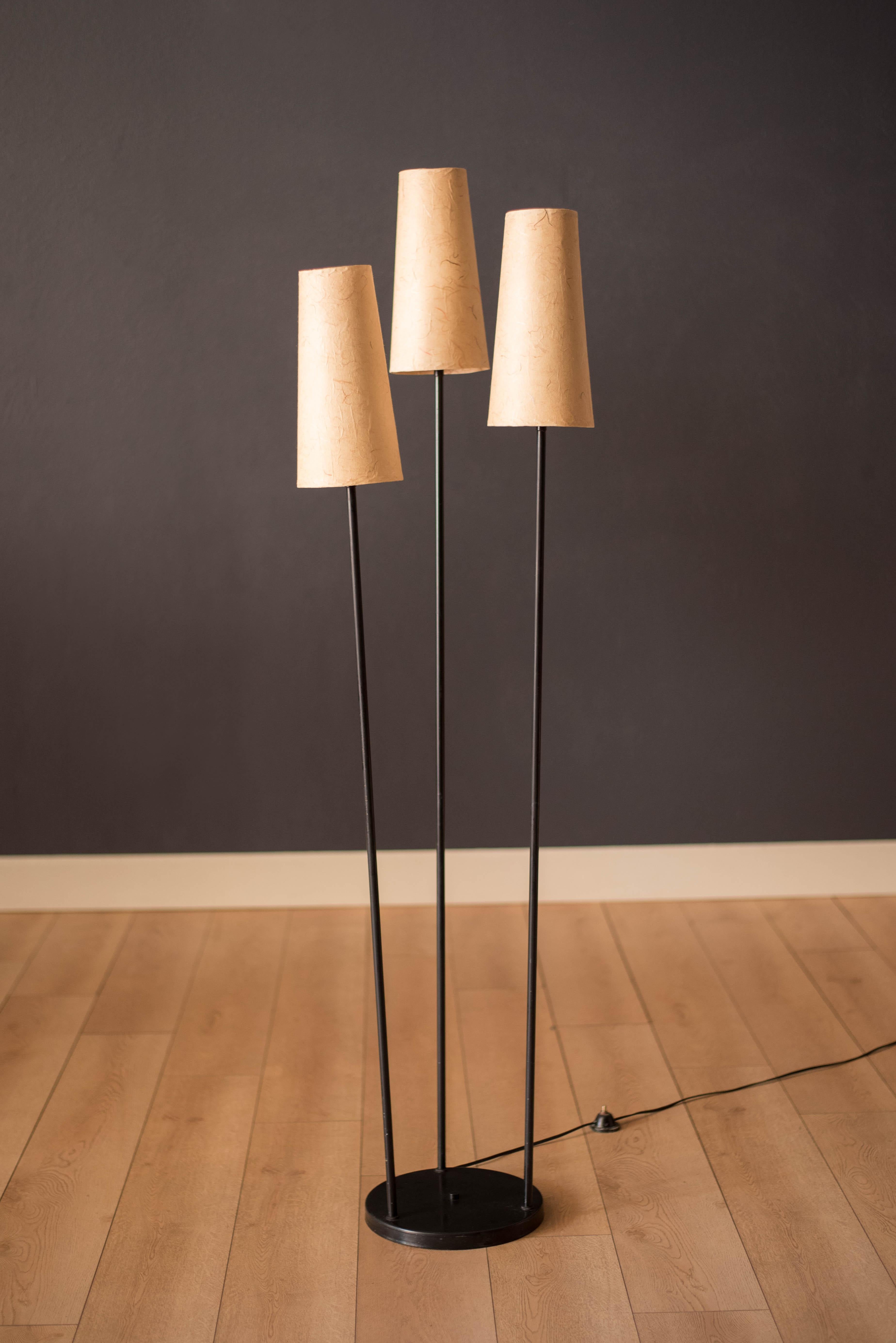 Classic vintage triple light floor lamp circa 1960's. This unique piece features three tapered parchment fiber shades that emits a soft warm glow. Supporting base is made out of metal construction finished in black enamel. 





Offered by Mid