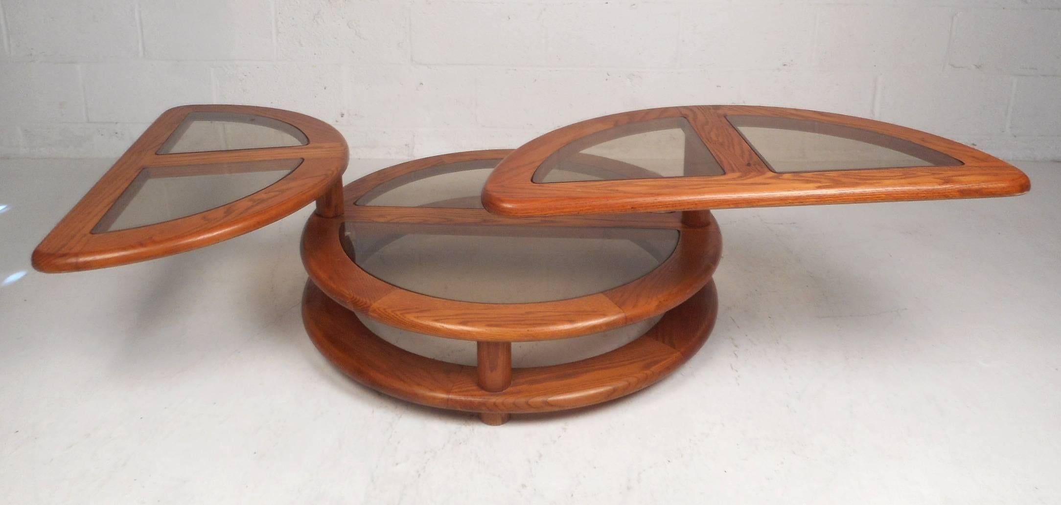 This versatile vintage modern coffee table features the unique ability to expand all the way to 63.5 wide and strategically adjust to the most convenient spot. Two half moon shaped tables on a swivel easily adjust to the most convenient place and