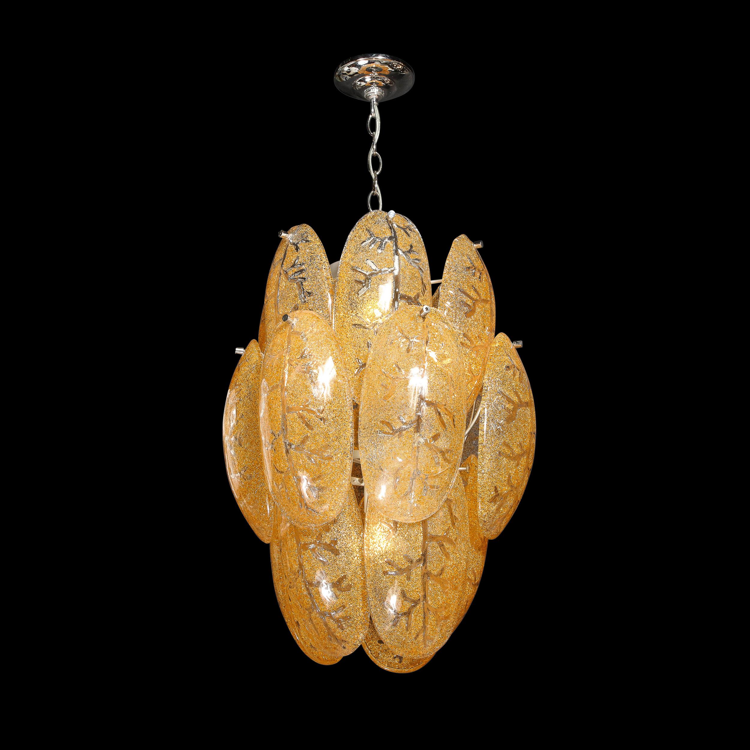 This stunning and impactful Mid-Century Modern chandelier was realized in Murano, Italy- the island off the coast of Venice renowned for centuries for its superlative glass production. It offers three tiers of handblown Murano ovoid leaf form