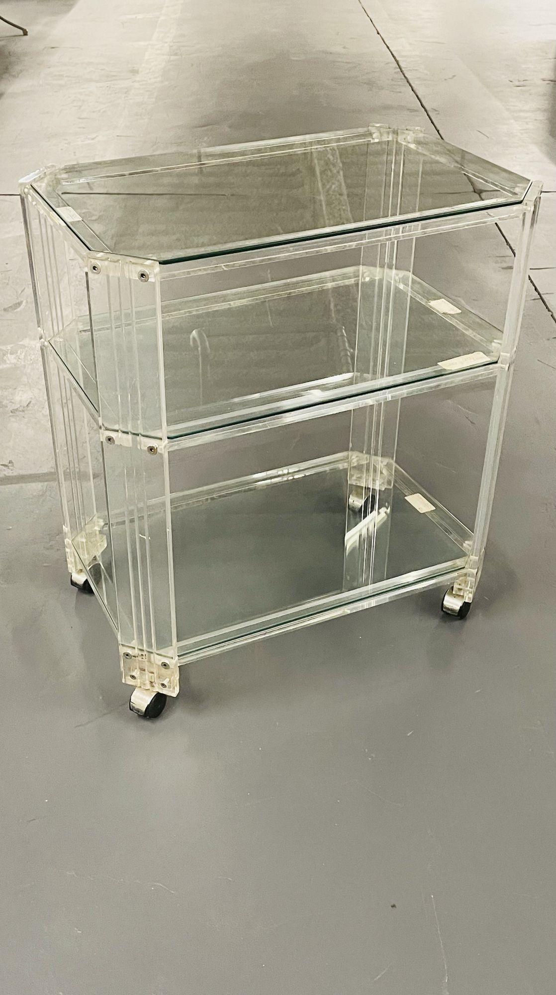 Mid-Century Modern three tier rolling bar, cart or server, lucite.
 
A finely constructed sleek and stylish mid century modern dry bar, serving cart, or server. The chrome circular wheels make moving this cart effortless. The reeded sides having