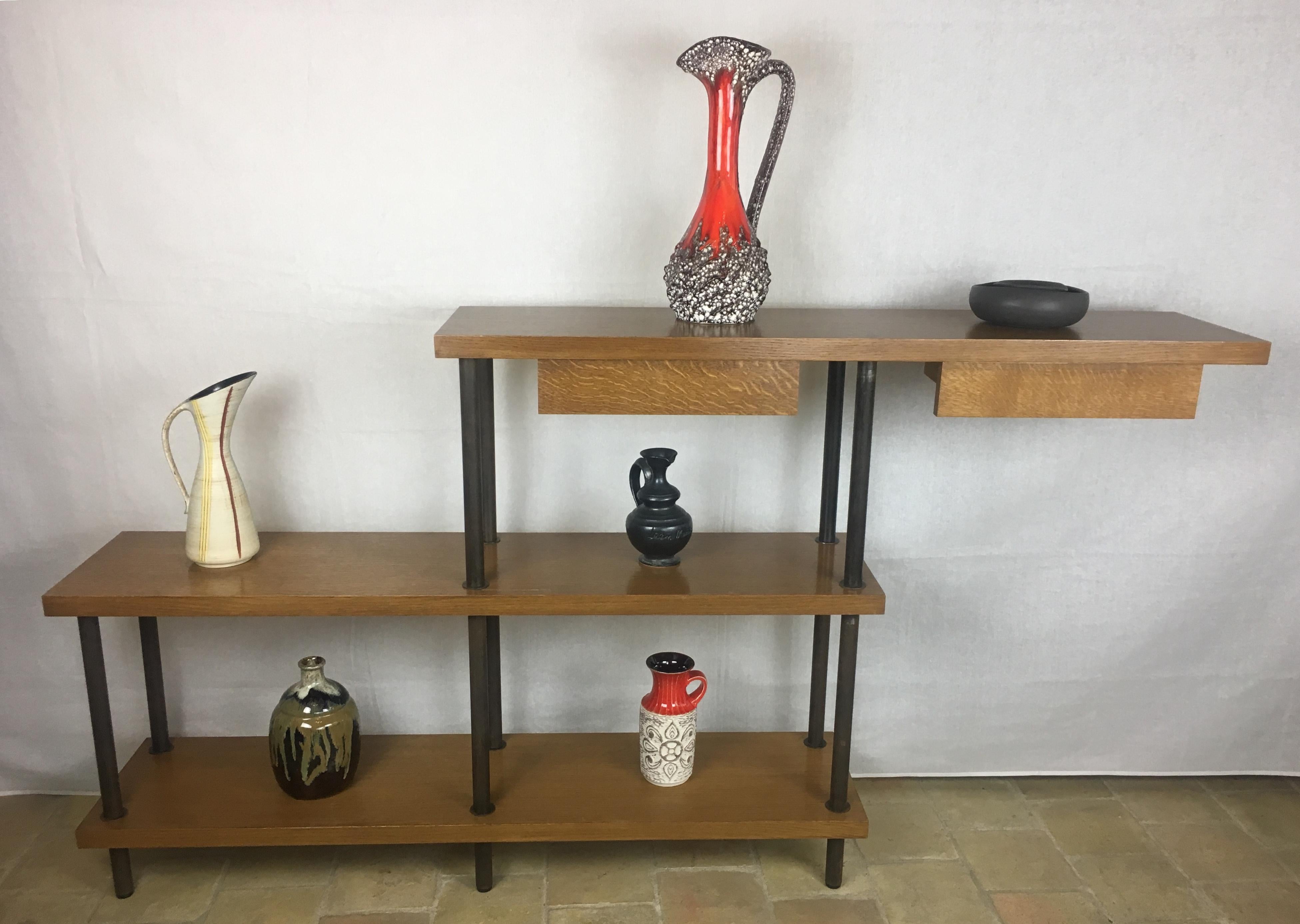 Solid oak and iron on this 1950s McCobb style bookshelf or freestanding display unit.
Excellent condition.

The iron has a beautiful patina and would great in any midcentury or contemporary space. 
Drawers can be positioned on either side of the top